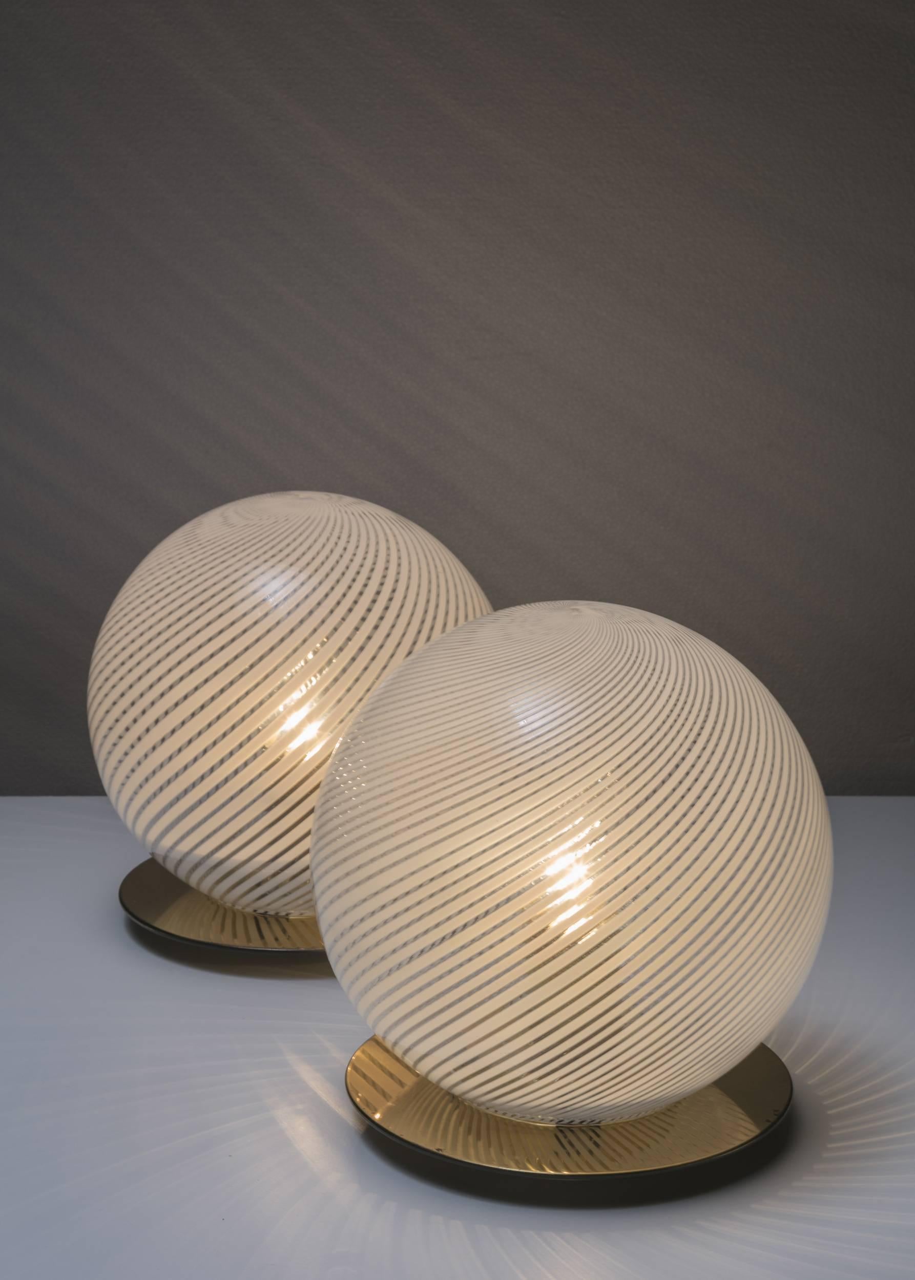 Set of two Tessuto table lamps by Tronconi.
Milky and crystal Murano glass shades and brass base.