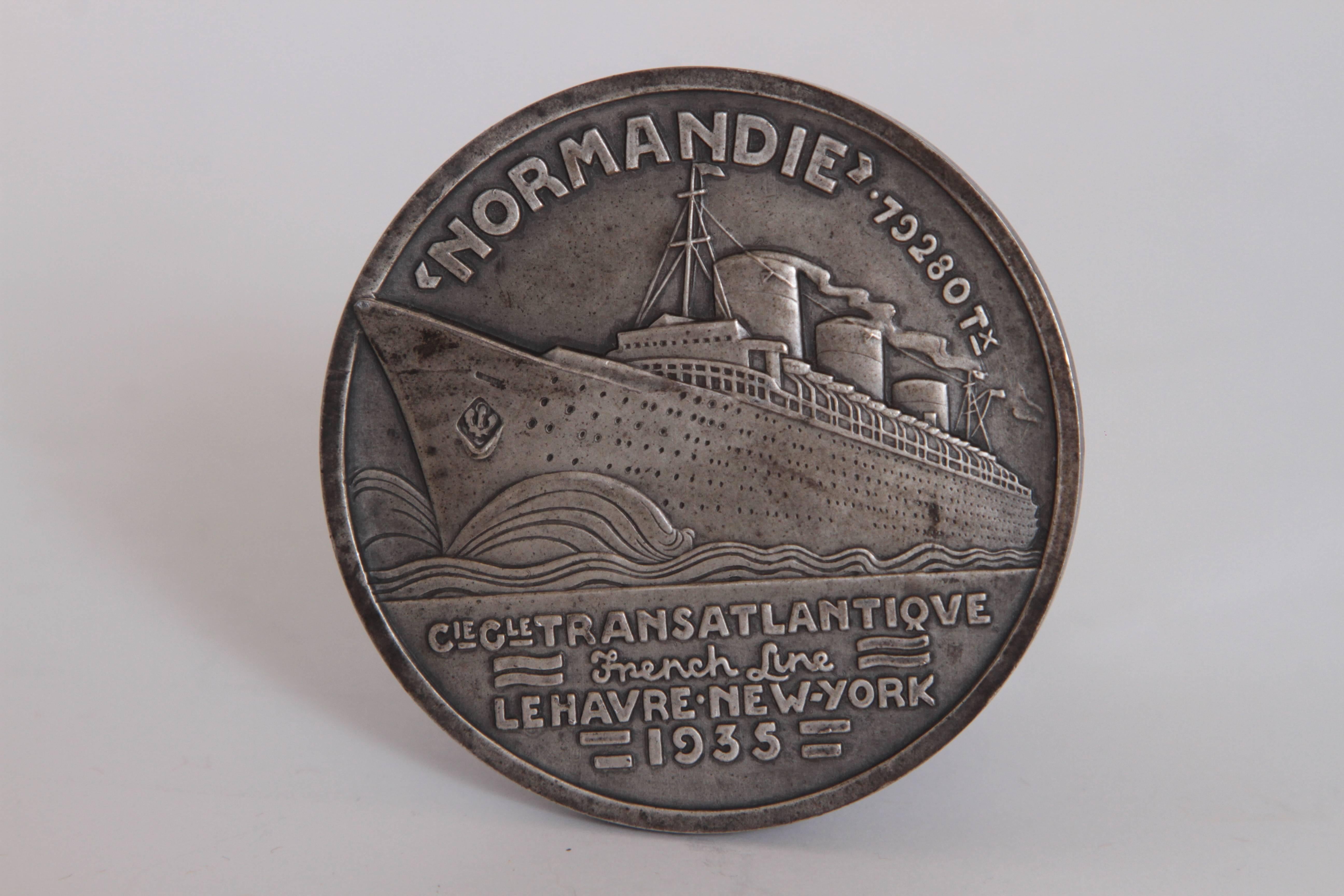 Art Deco French Normandie medallion by Jean Vernon silvered bronze

Iconic Jean Vernon Normandie maiden voyage Medallion, 1935 design.
Struck by the Paris Mint for the inaugural CGT French Line trans-Atlantic voyage from Le Havre to New York in