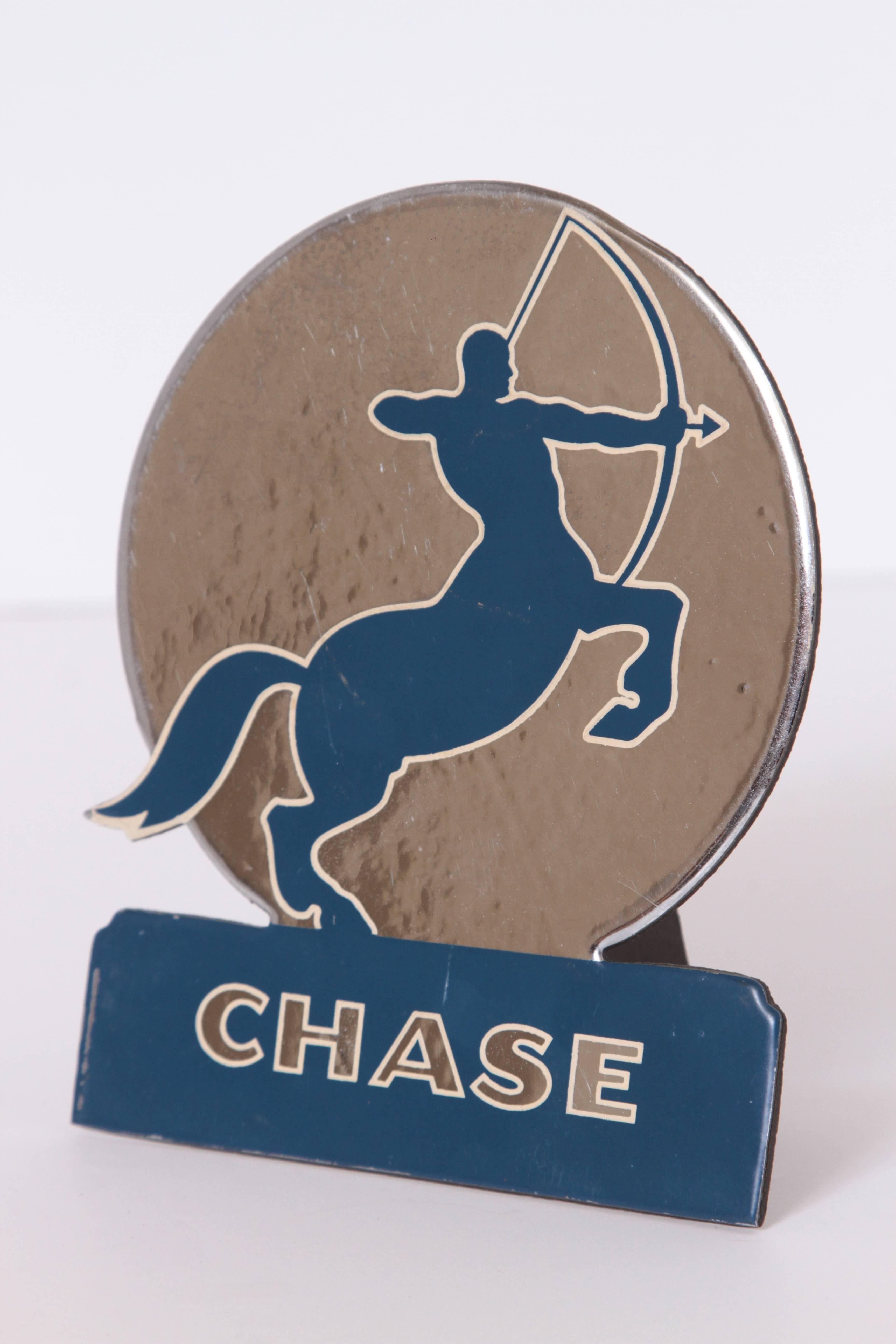 Art Deco 1930s chase brass and copper company advertising stand.

Rare iconic chase centaur with long-bow logo.
Embossed foil in silver, blue and white over cardboard counter-top foldout stand.
Extremely difficult to source vintage advertising