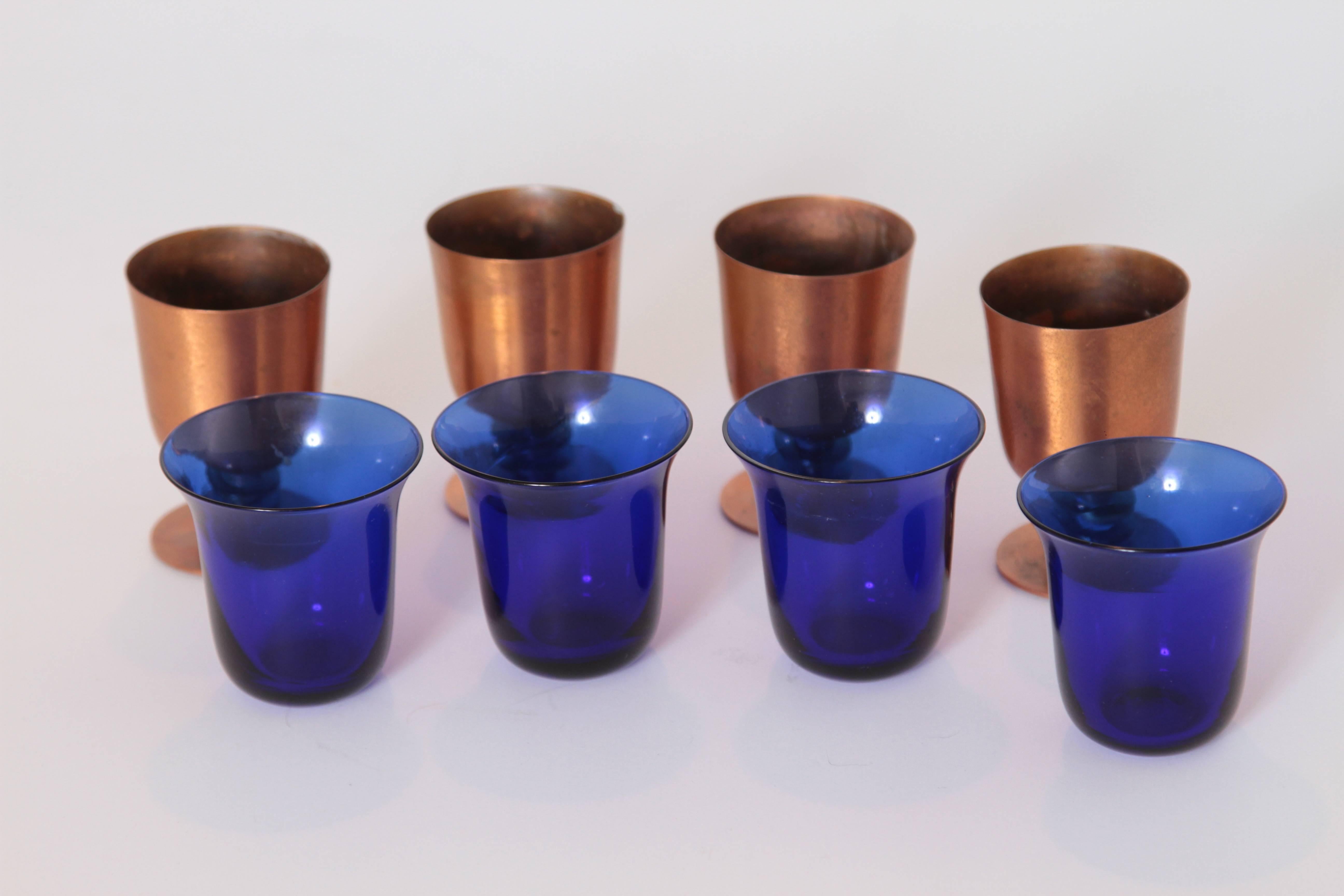 Machine Age Art Deco Walter Von Nessen cocktail cups, set of four in copper and brass with cobalt glass.

Three in chrome also available.
Iconic Nessen - style ringed design.
In the rare brushed copper base with brass rings.
Removable deep