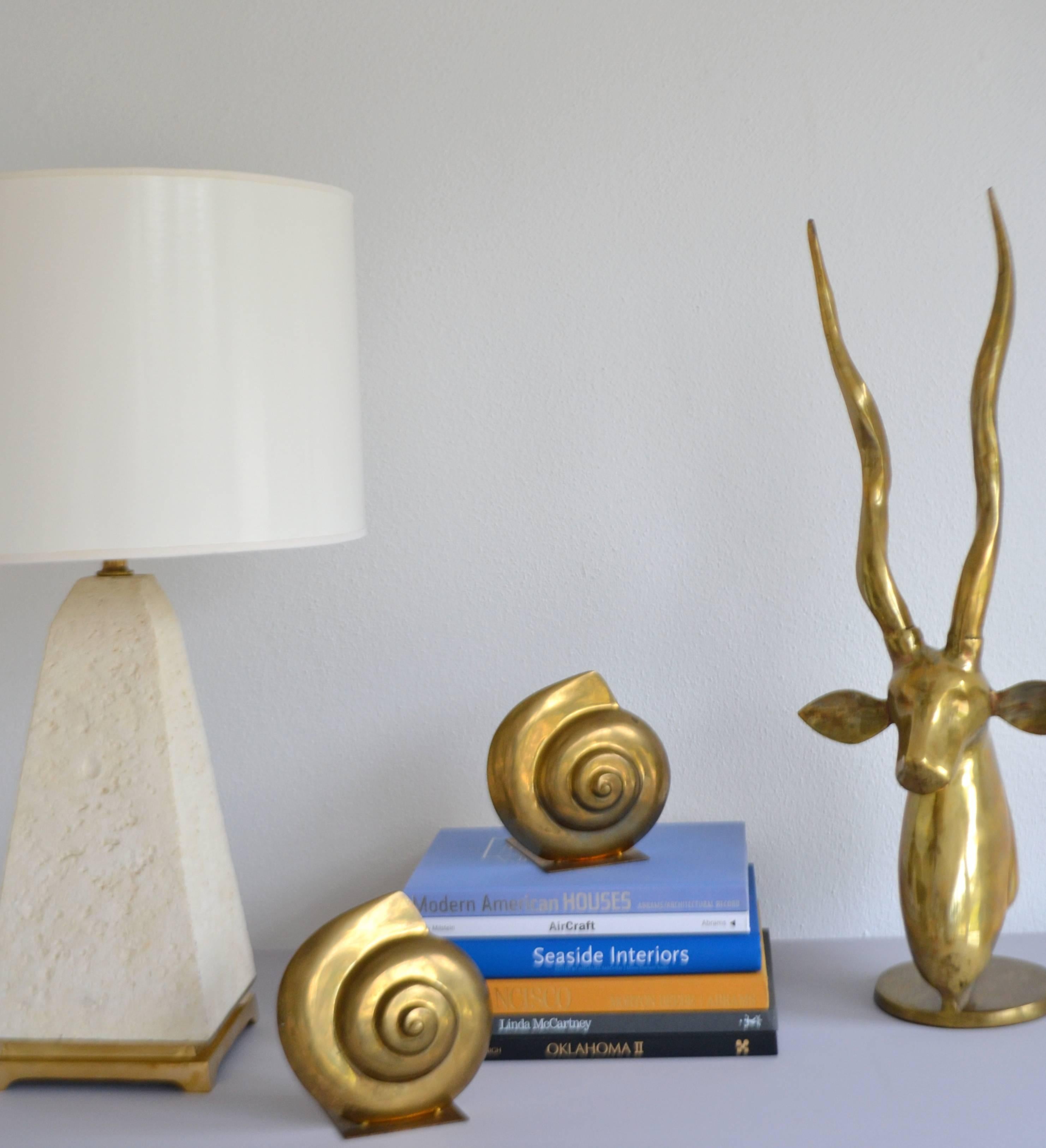 Glamorous pair of Hollywood Regency brass nautilus form bookends, circa 1950s -1960s. This stunning decorative garniture is in excellent original condition with a wonderful oxidized patina.