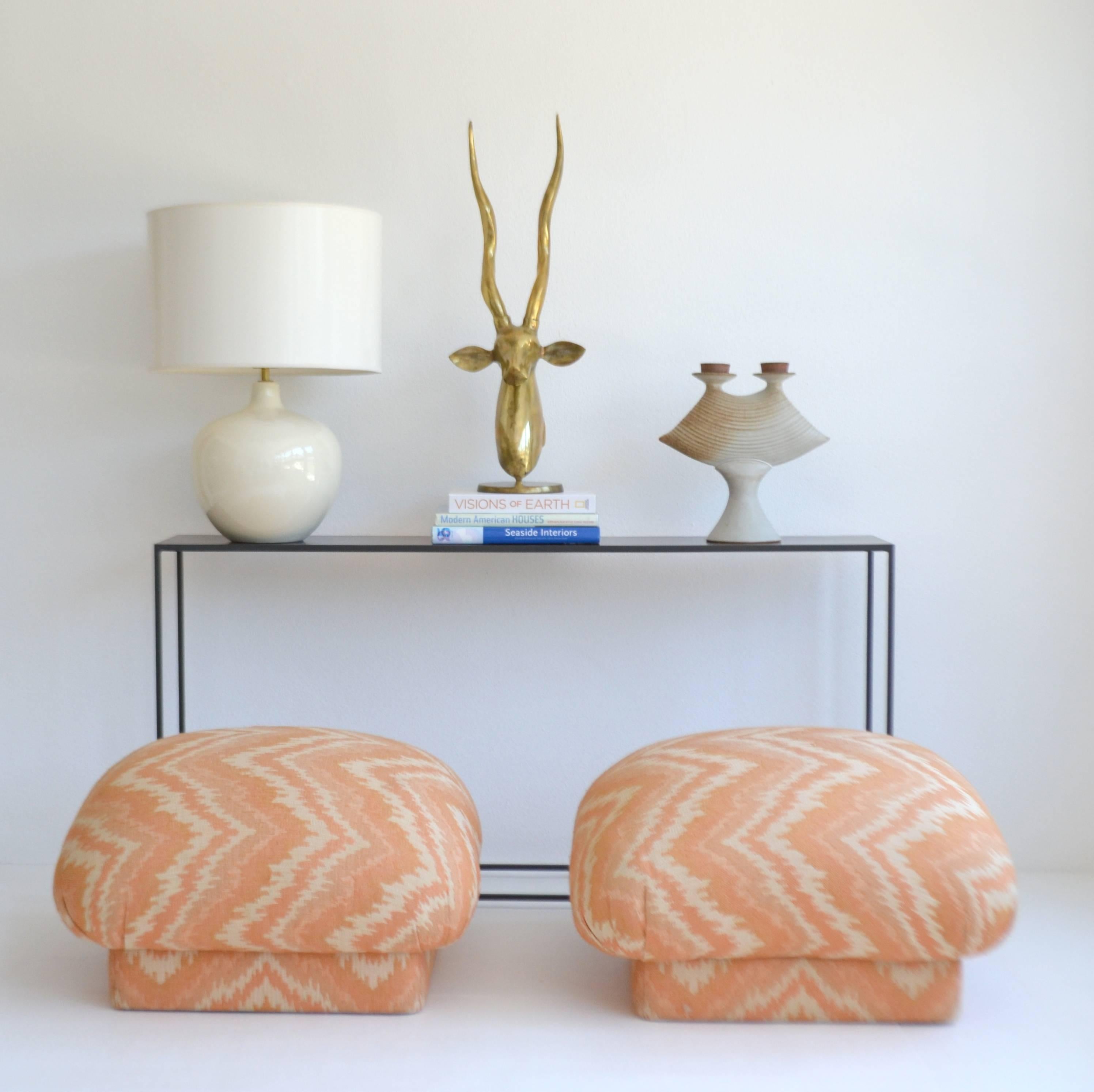 Stunning pair of midcentury upholstered stools, circa 1970s. These custom souffle form benches with inset bases are upholstered in the original coral and cream flame stitch pattern fabric. Light staining from normal wear, stools need reupholstering.