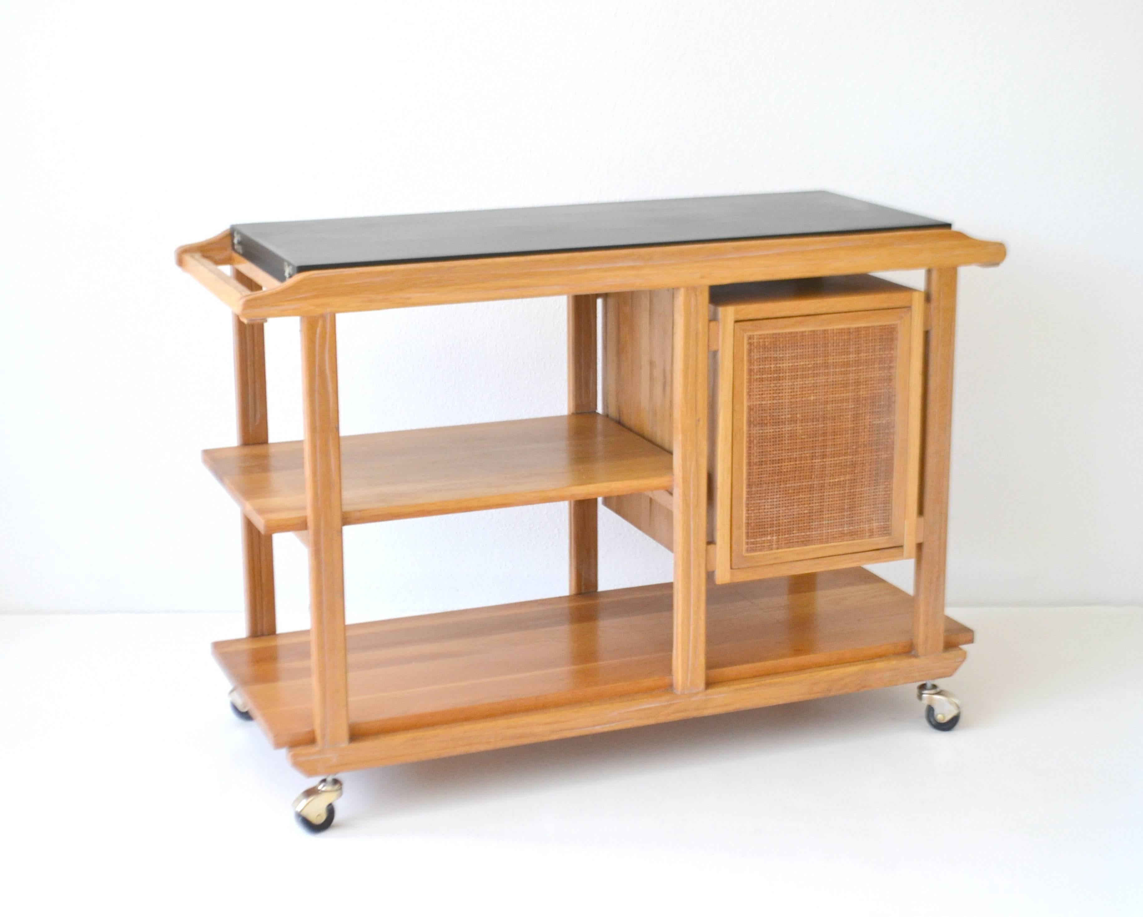 Striking Mid-Century rolling bar cart or sideboard by Edward Wormley, circa 1950s. This architectural and sculptural serving cart is designed of cerused sap grain walnut with a cantilevered arrangement of shelves and a floating cabinet designed with