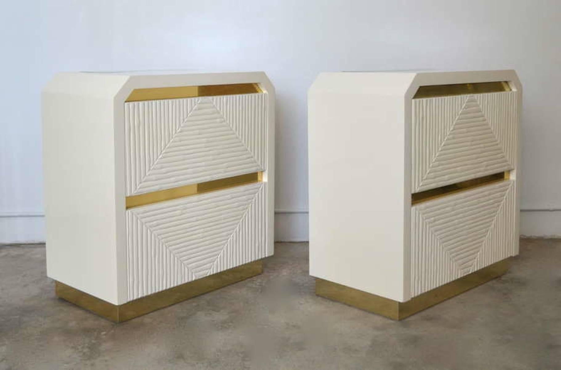 Glamorous pair of post-modern white lacquered faux bamboo side tables, circa 1970s. These incredible night tables are mounted on recessed brass bases. Each end table is custom designed with an interior illuminated upper cabinet over a lower drawer