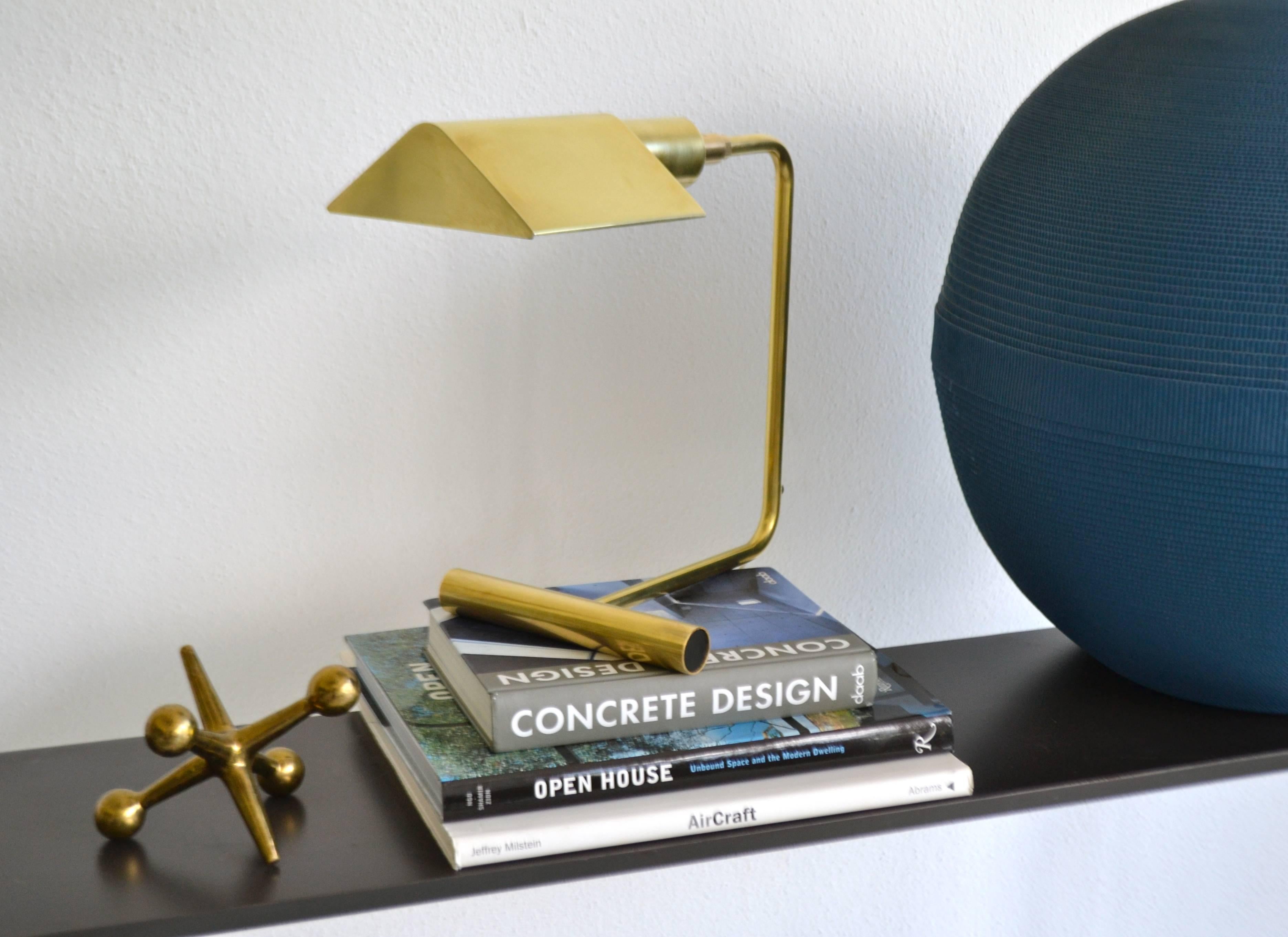 Sculptural midcentury polished brass desk lamp by OMI, circa 1960s-1970s. This architectural table lamp is designed with an articulating shade and a dimmer switch for directional and adjustable lighting. The Koch & Lowy desk lamp is crafted with a