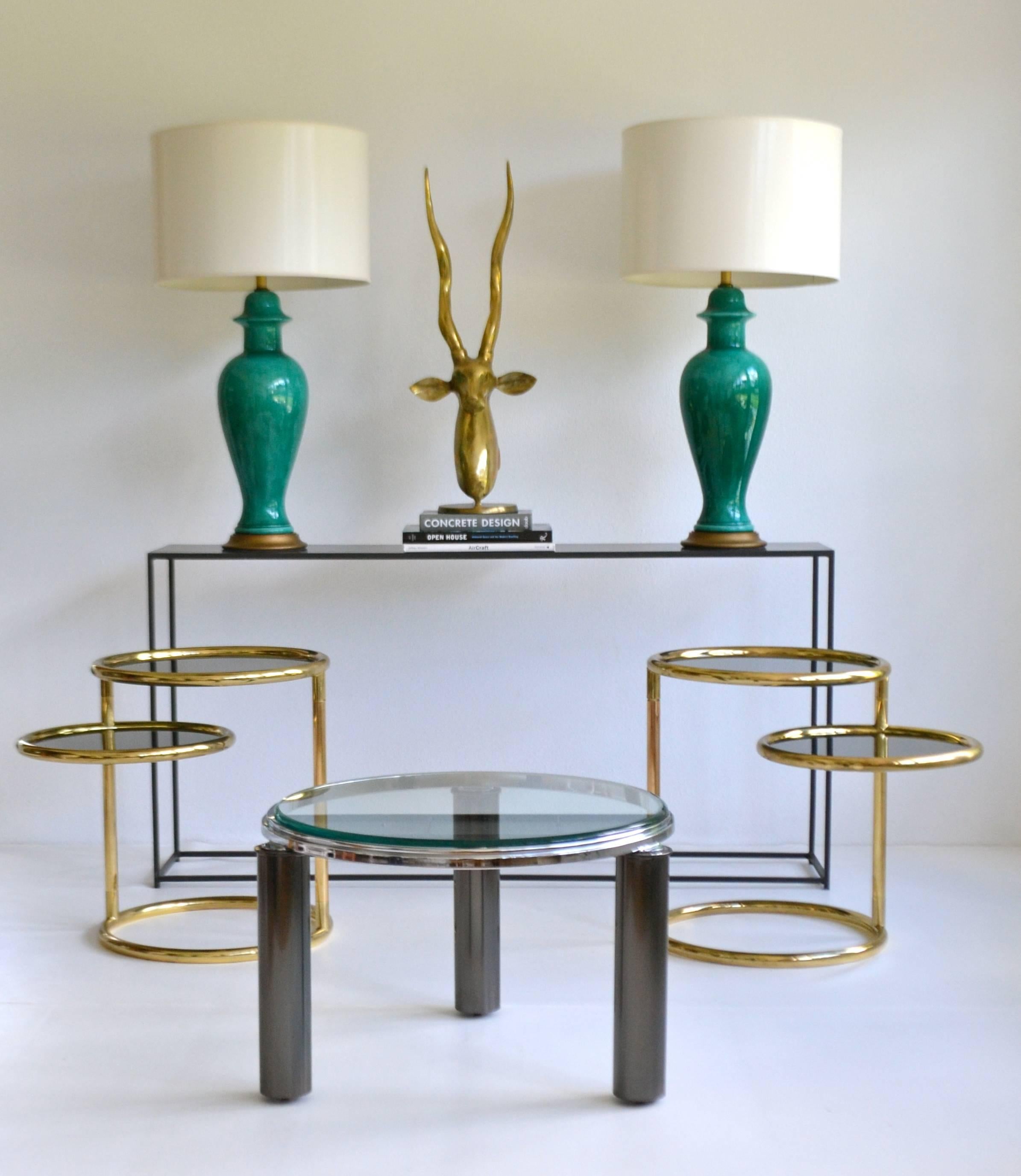 Postmodern architectural gunmetal and chrome side table, circa 1980s. This striking custom crafted round occasional table is designed with three gunmetal tubular legs with recessed hidden casters and accented with a glass top. Attributed to Design