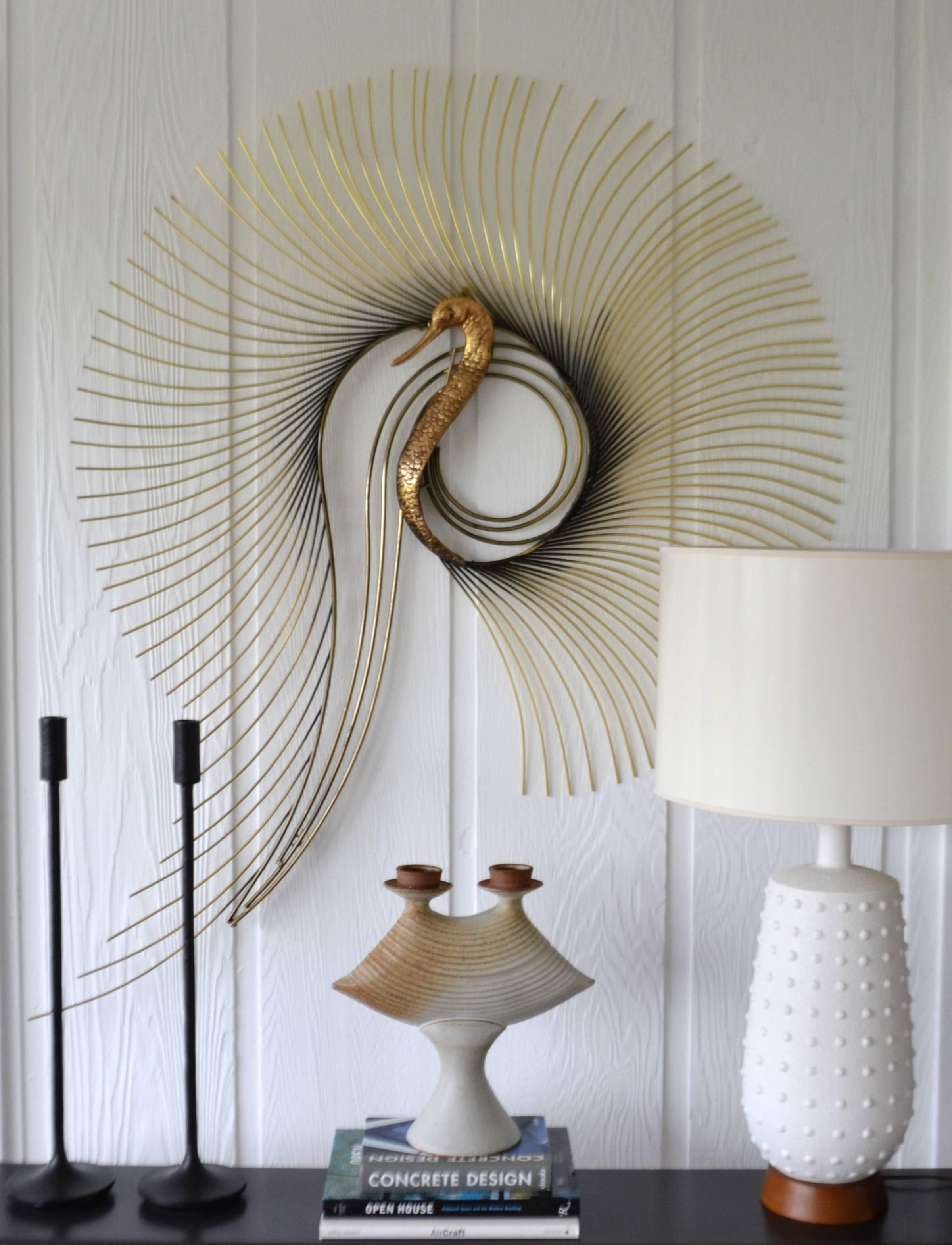 Glamorous midcentury brass peacock wall sculpture by Curtis Jere, circa 1987. This stunning large-scale artisan crafted sculpture is designed with a polished brass body and heavy gauge brass rods creating a stylized spiraling feathering effect.