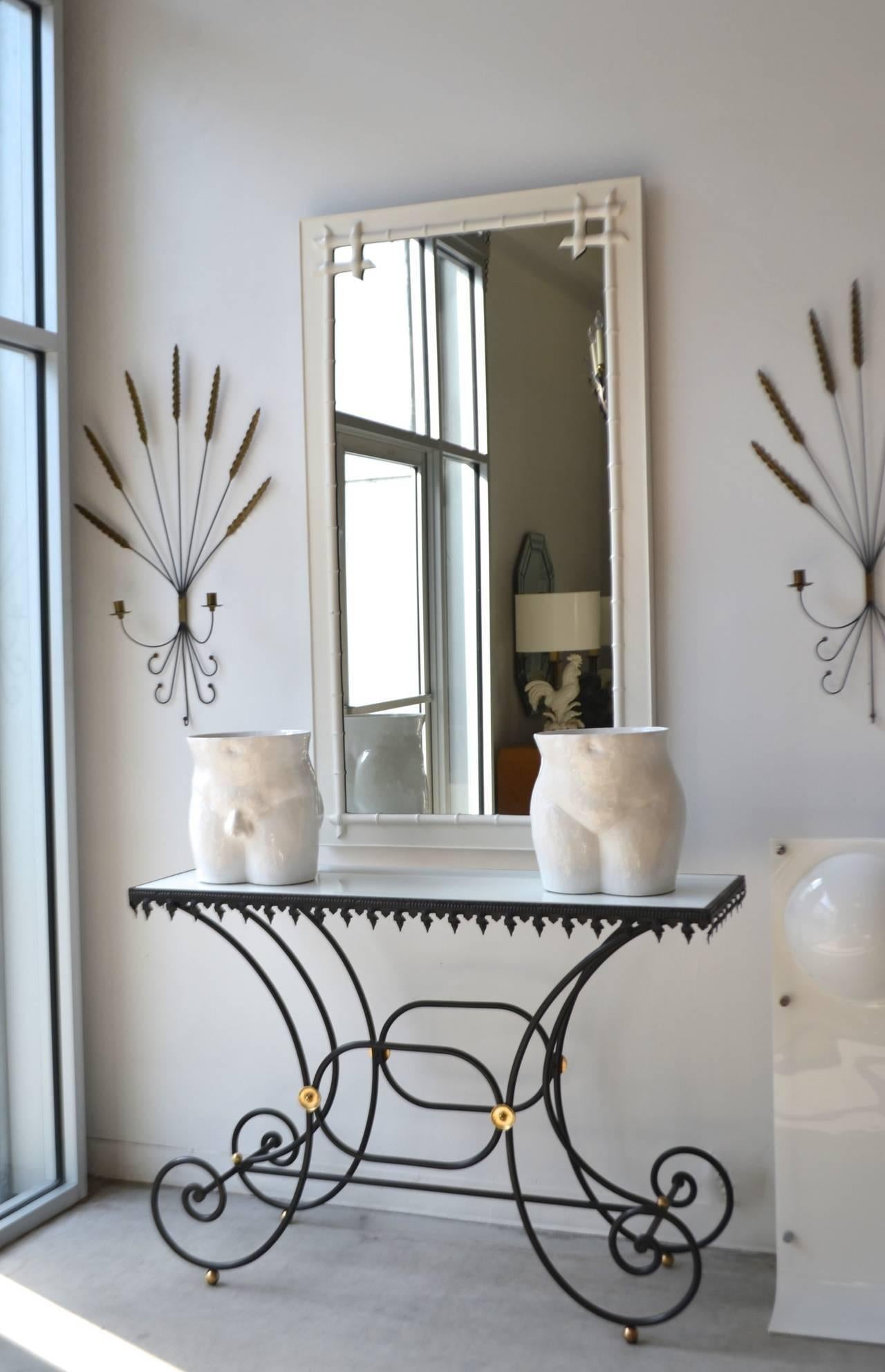 Stunning French Hollywood Regency console table, circa 1950s-1960s. This striking bakers table is designed with a scrolling wrought iron base, an inset white milk glass top and embellishments with brass accents.
   