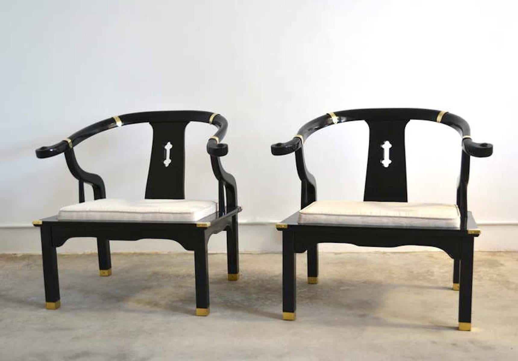 Exquisite pair of Hollywood Regency Asian inspired black lacquered club chairs / lounge chairs, circa 1950s-1960s. These highly decorative Asian inspired armchairs / occasional chairs are upholstered in a natural ivory moire patterned fabric. The