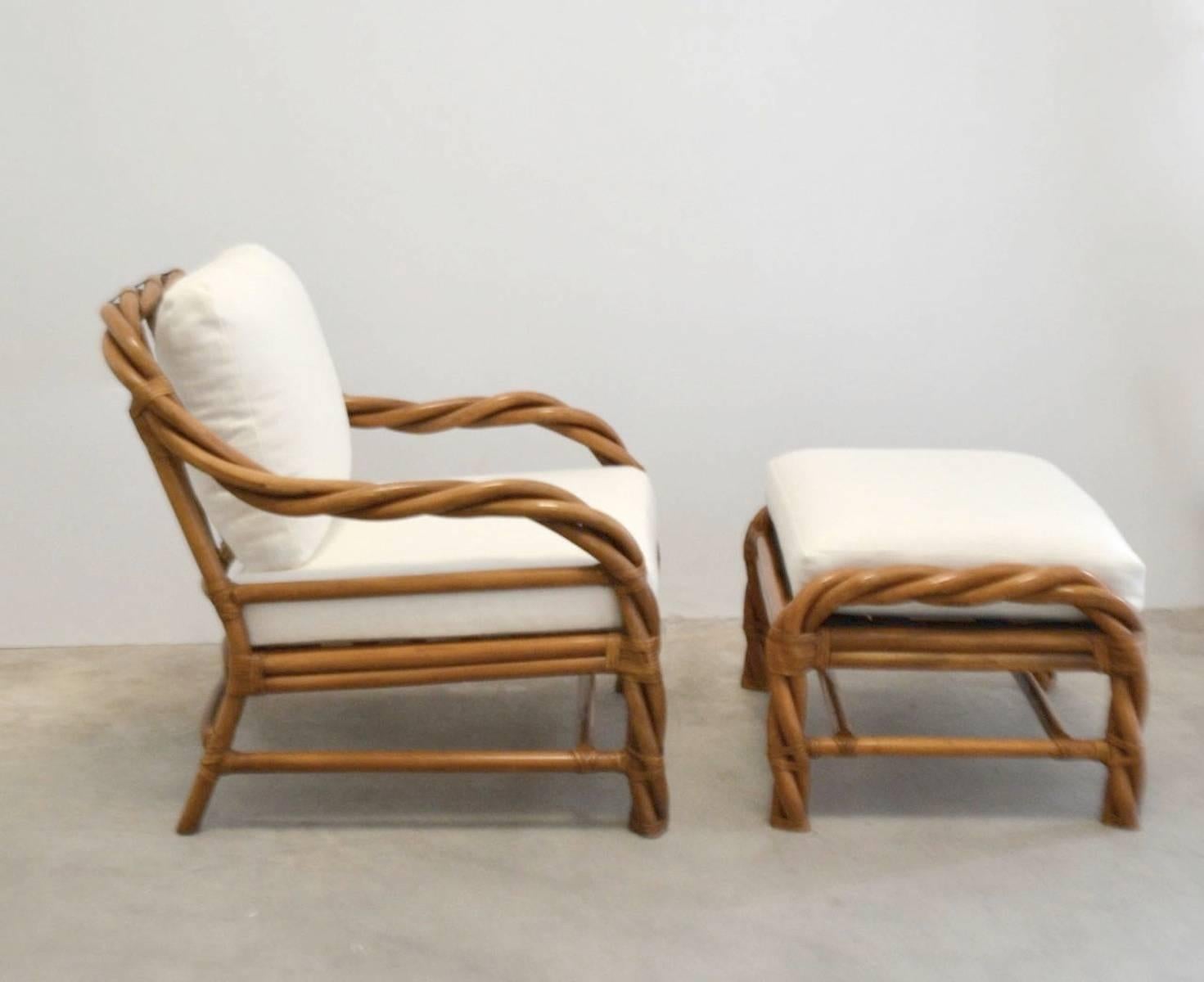 Striking Mid-Century intertwined bent rattan or cane and rawhide joint wrapped club chair and ottoman, circa 1960s. This lounge chair has been newly reupholstered in a cotton linen fabric. 
Chair is 31