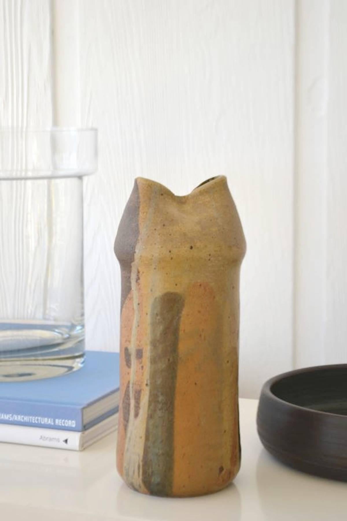 Sculptural midcentury hand thrown ceramic organic form vase, circa 1975. This striking artisan vessel is drip glazed with alternating colors/shapes and designed with tactile impressions and a pinched opening.