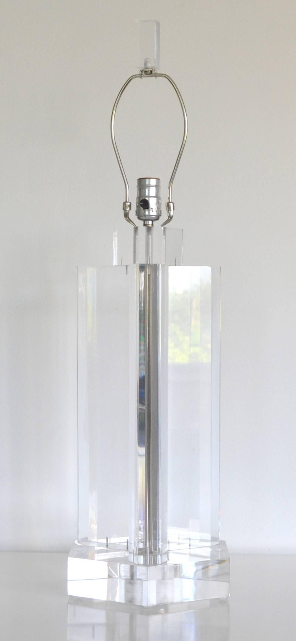 Glamorous midcentury geometric form Lucite table lamp, circa 1960s-1970s. This stunning artisan crafted lamp is sculptural in both design and dimension. Wired with chrome fittings and topped with a Lucite finial. Shade not