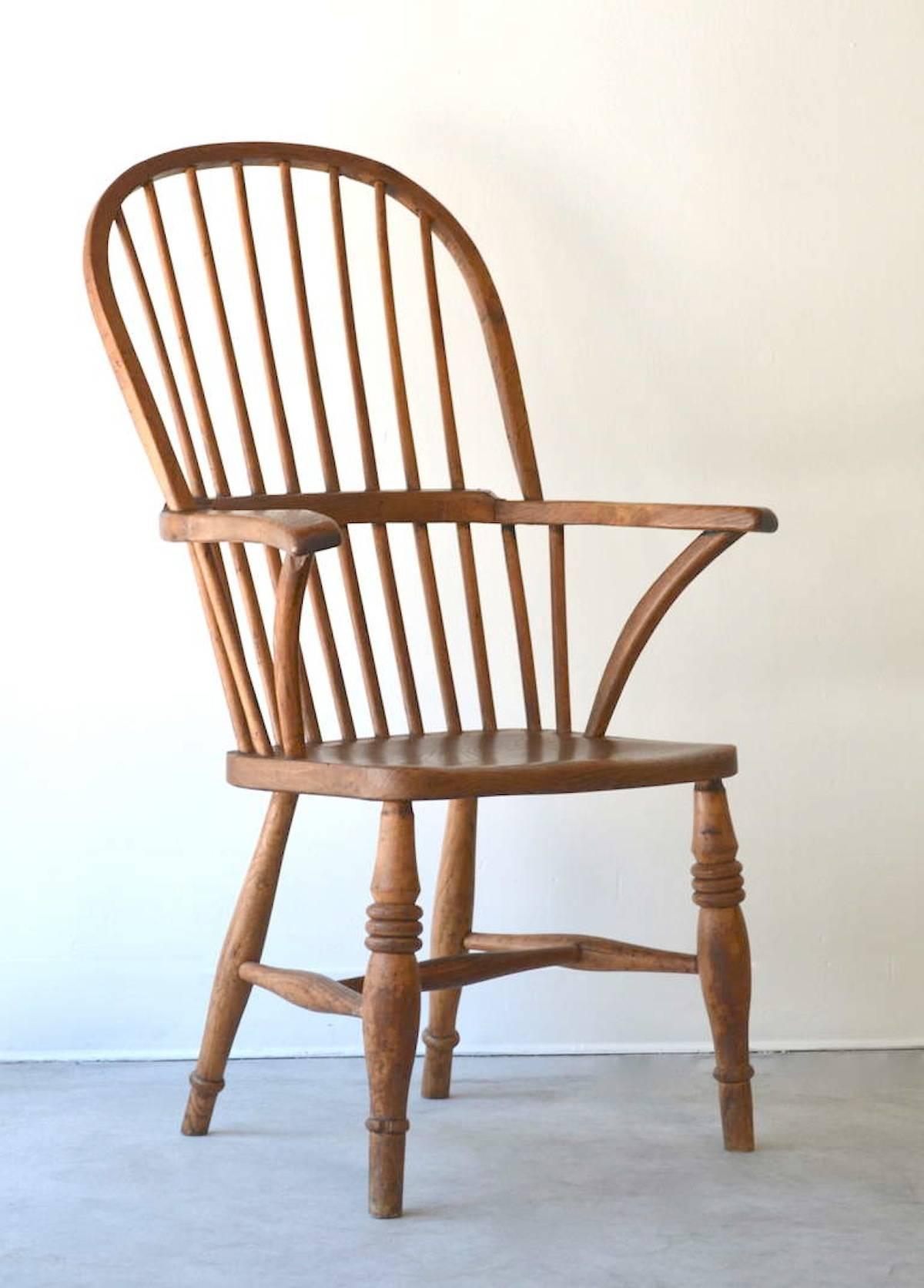 Bow-back broad armed windsor chair, circa 19th century. This sculptural hardwood side chair or desk chair maintains its wonderful aged patina.
