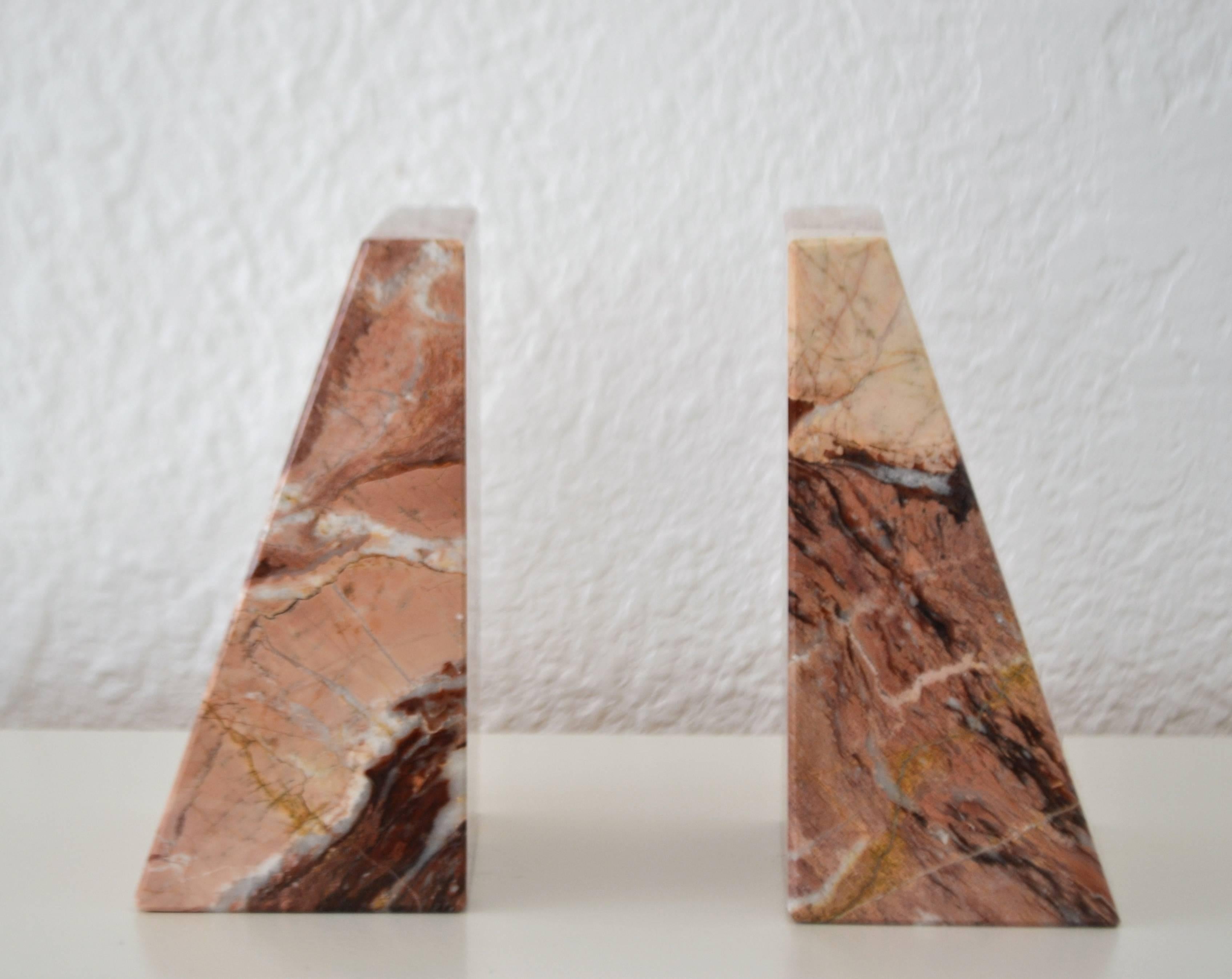 Striking pair of Italian midcentury marble bookends, circa 1960s-1970s.
These sculptural geometric form bookends are designed of a tea rose marble with variegated veining accents.