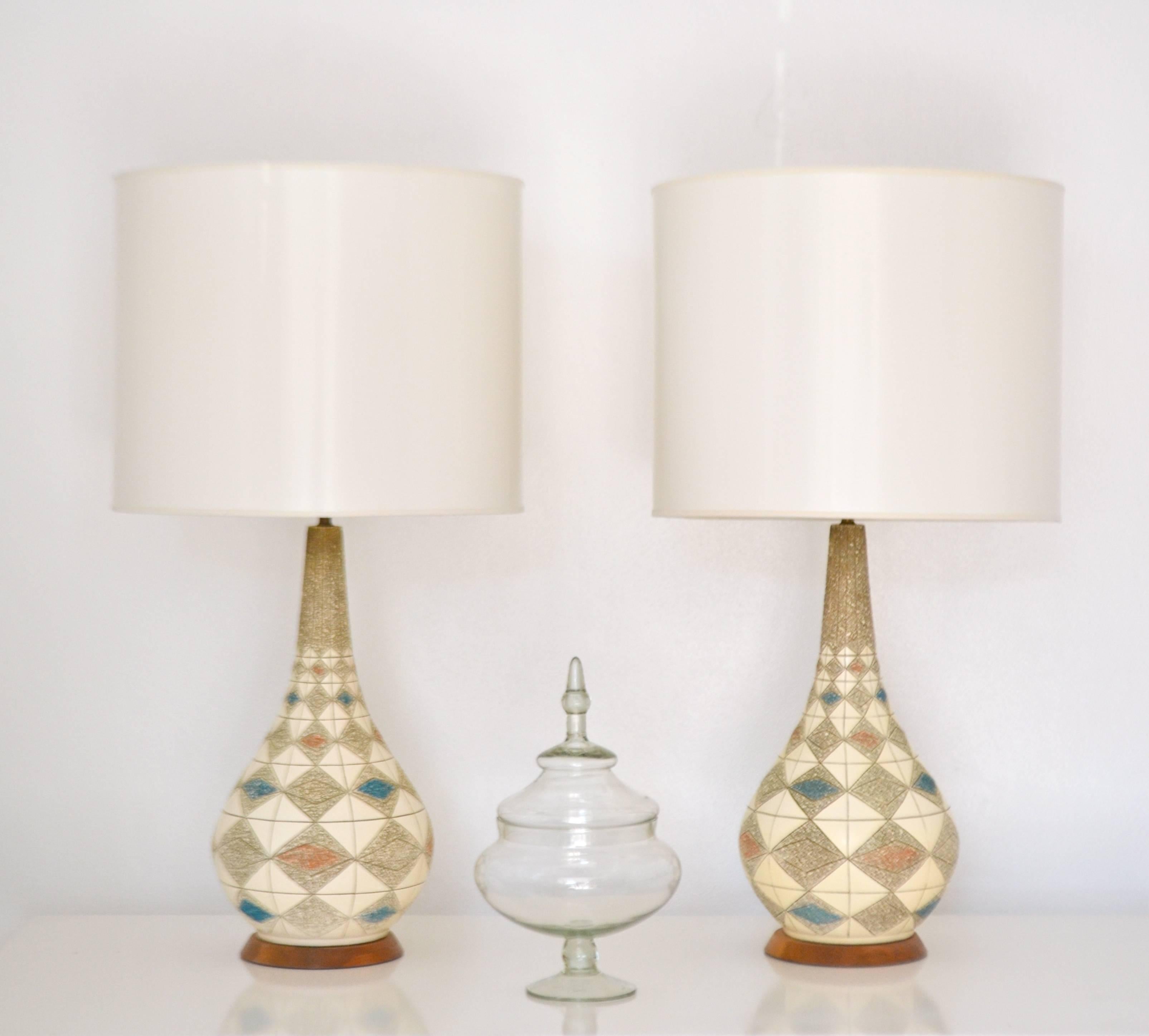 Striking pair of midcentury ceramic table lamps, circa 1950s -1960s. These stunning polychrome glazed highly graphic and decorative lamps are mounted on turned walnut bases and wired with brass fittings. Shades not included.
Measurements: 38