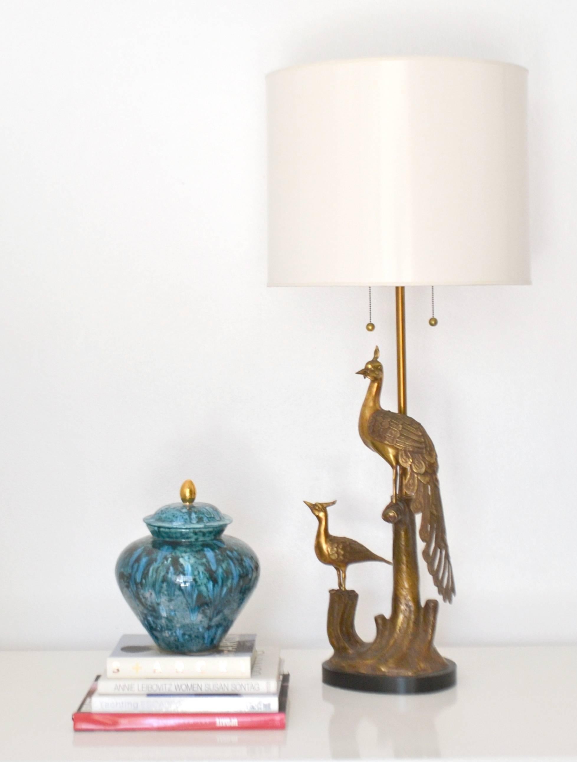 Mid-Century patinated brass sculptural peacock form table lamp by the Markoff brothers of The Marbro Lamp Company, circa 1950s. This striking artisan crafted lamp is mounted on an ebonized base and wired with brass double cluster fittings. Shade not