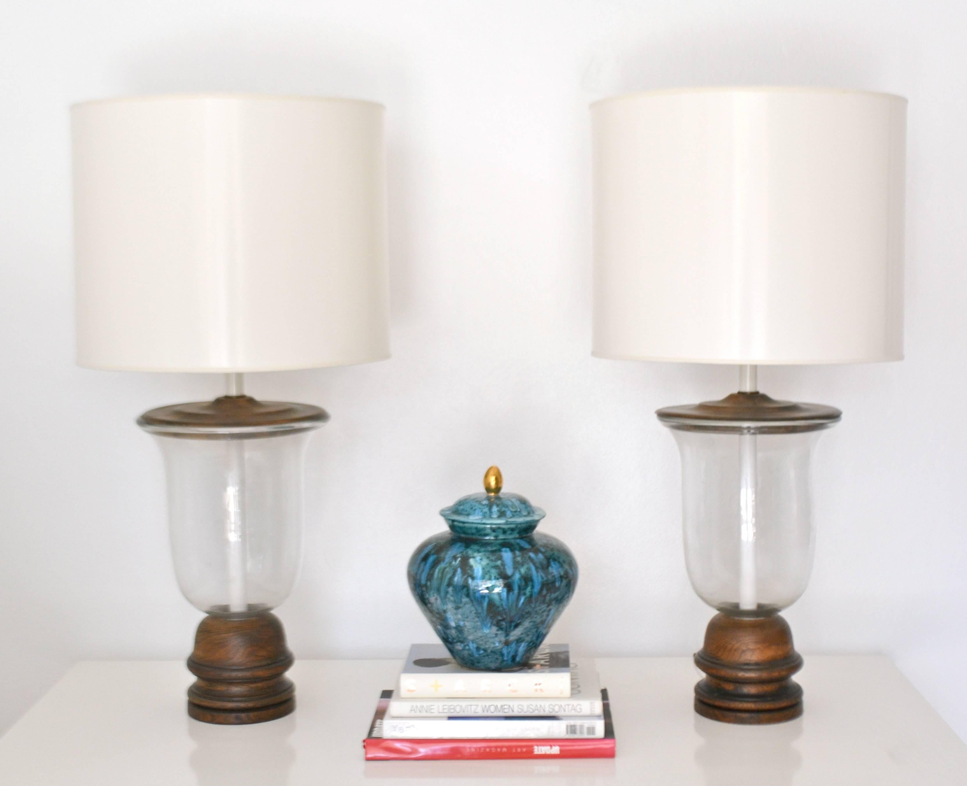 Stunning pair of Mid-Century blown glass bell jar form table lamps, circa 1950s-1960s. These highly decorative clear blown glass lamps are mounted on hand-turned oak bases and rewired with antique brass adjustable double cluster fittings. Shades not