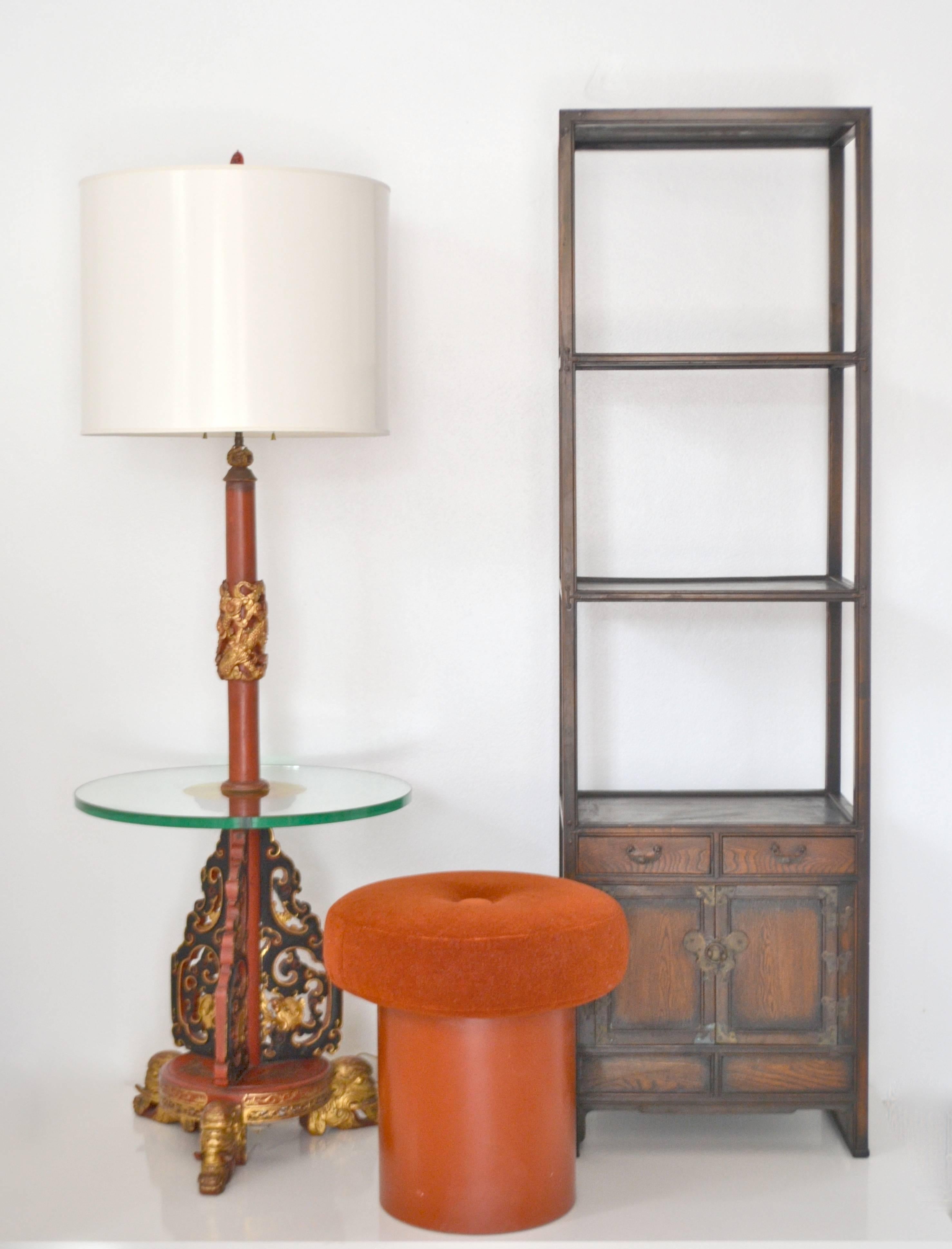 Glamorous Hollywood Regency Asian floor lamp, circa 1940s-1950s. This striking standing lamp is exquisitely artisan crafted of carved wood in a japanned red and black finish with giltwood accents. The lamp is designed with a thick 3/4
