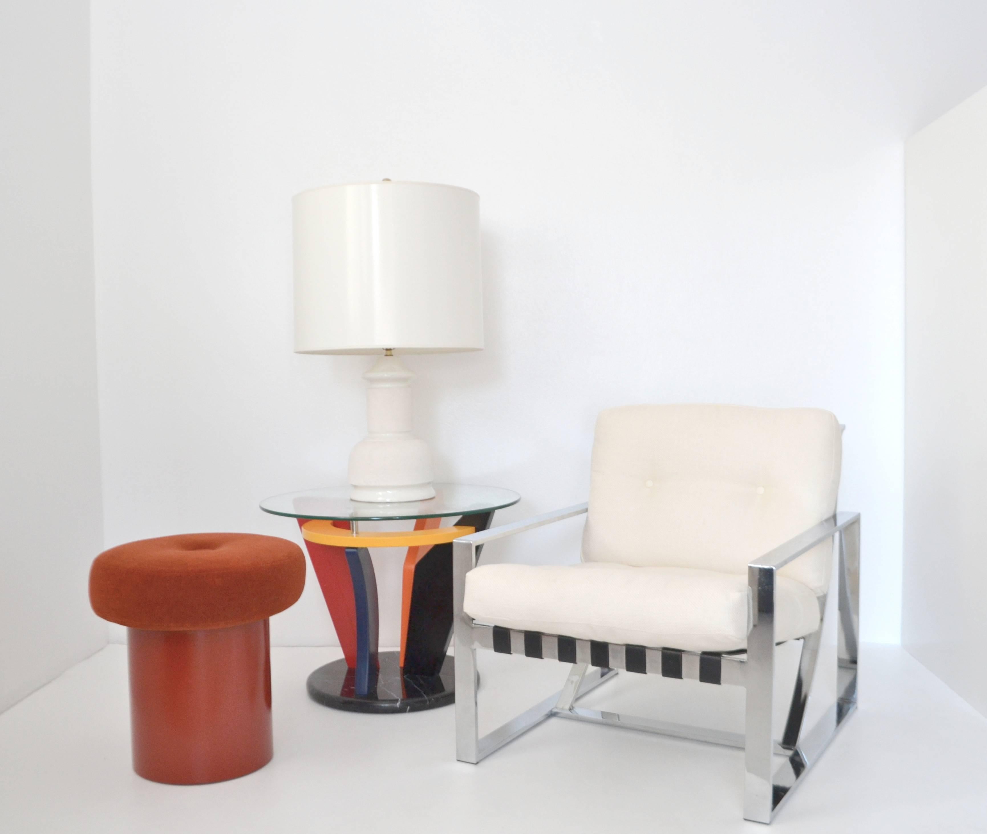 Striking pair of Italian Postmodern Memphis side tables, circa 1980s-1990s. These sculptural round end tables are artisan crafted of curved tubular horizontal chrome supports and lacquered colorful polychrome wood graphic geometric hardwood cut-outs