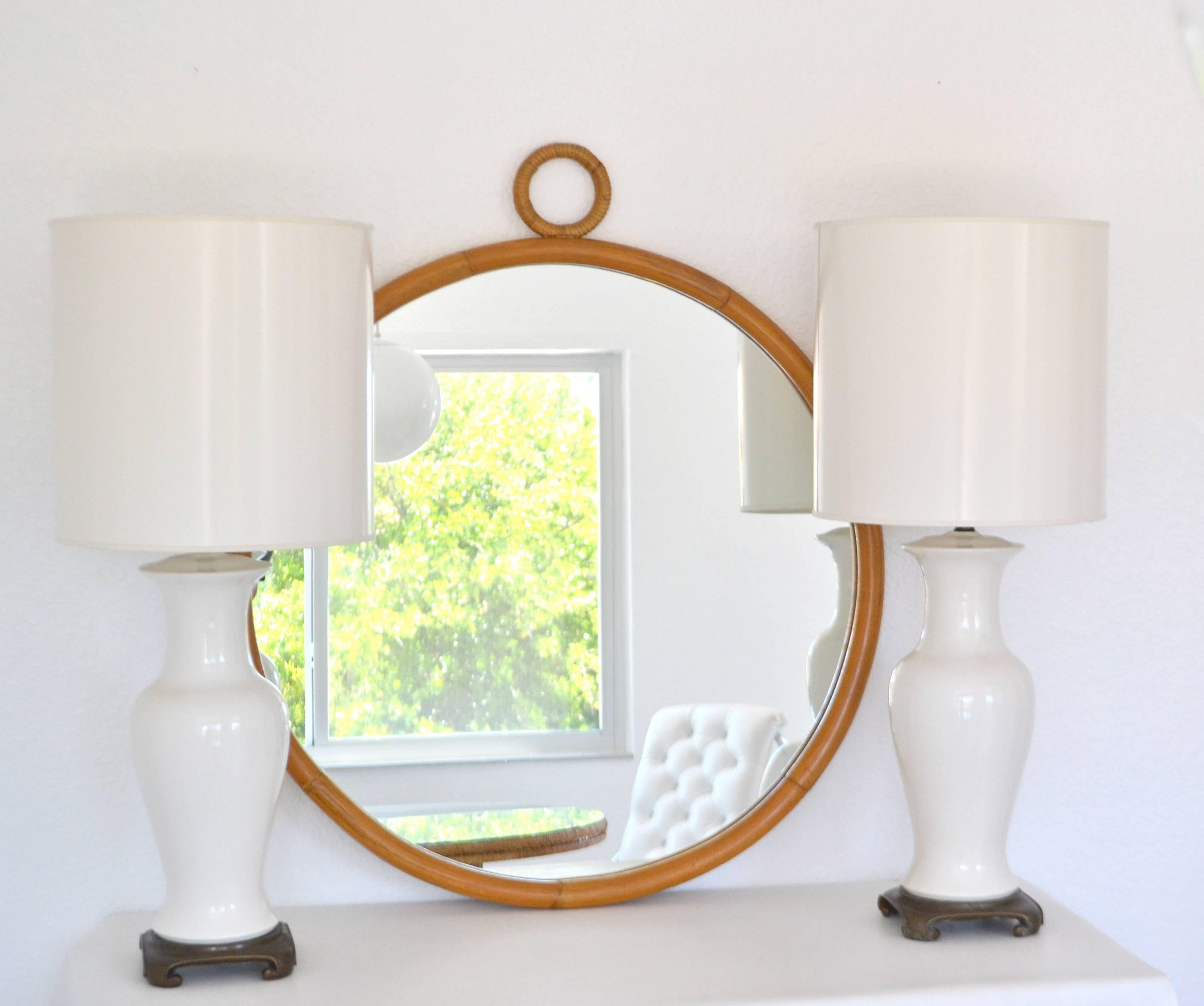 Glamorous Mid-Century bamboo wall mirror, circa 1960s-1970s. This stunning round Jacques Adnet / Gabriella Crespi inspired mirror is designed of bent bamboo and accented with wrapped rattan detail. Original excellent condition with a warm aged