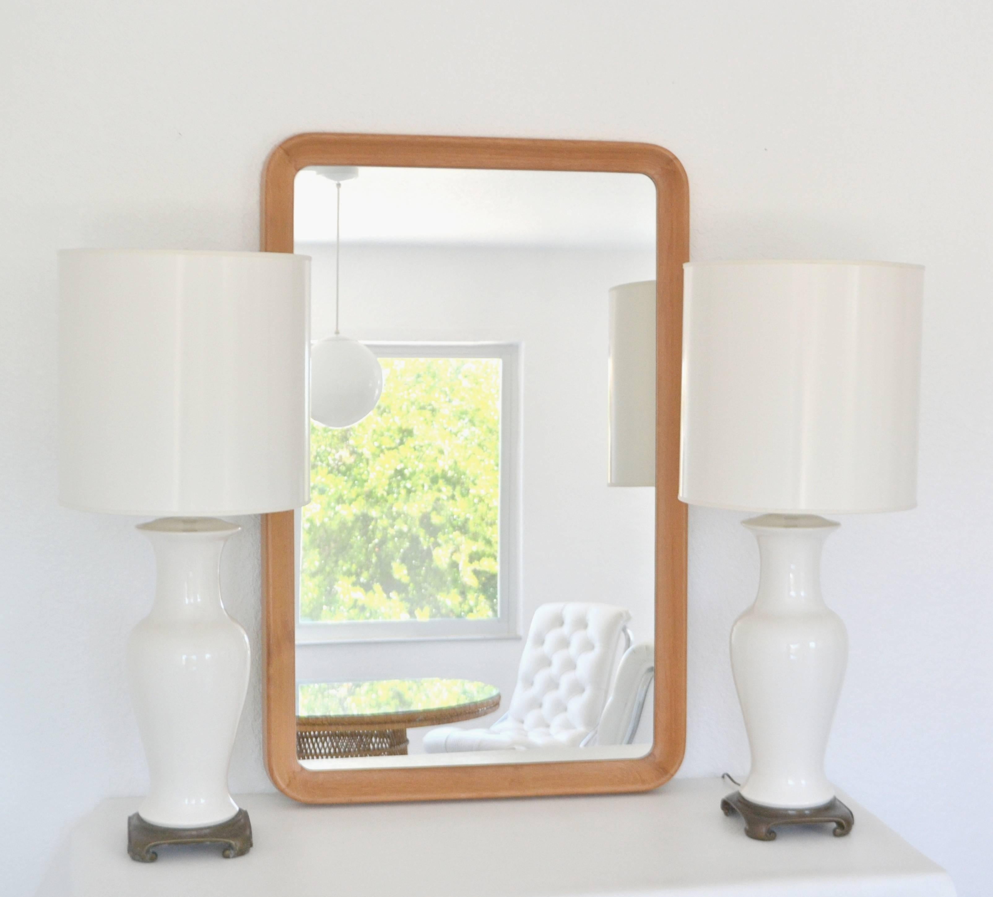 Striking midcentury teak rectangular form wall mirror, circa 1960s-1970s. This sleek and sculptural mantel mirror is designed with a deep concave teak surround frame with rounded corners.