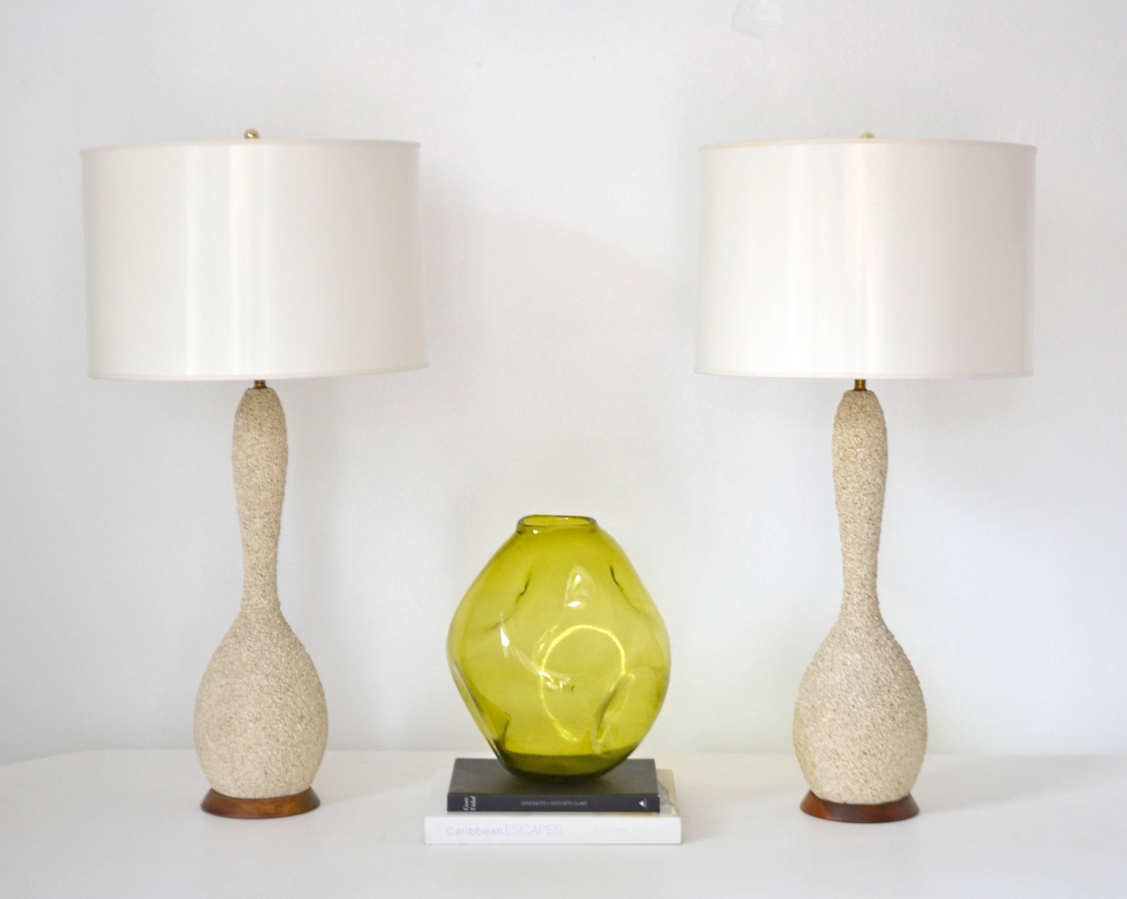 Stunning pair of Mid-Century sand glazed textured ceramic table lamps, circa 1950s-1960s. These artisan crafted hand thrown gourd form table lamps are mounted on turned wood bases and wired with brass fittings. Shades not included. 
Measurements: