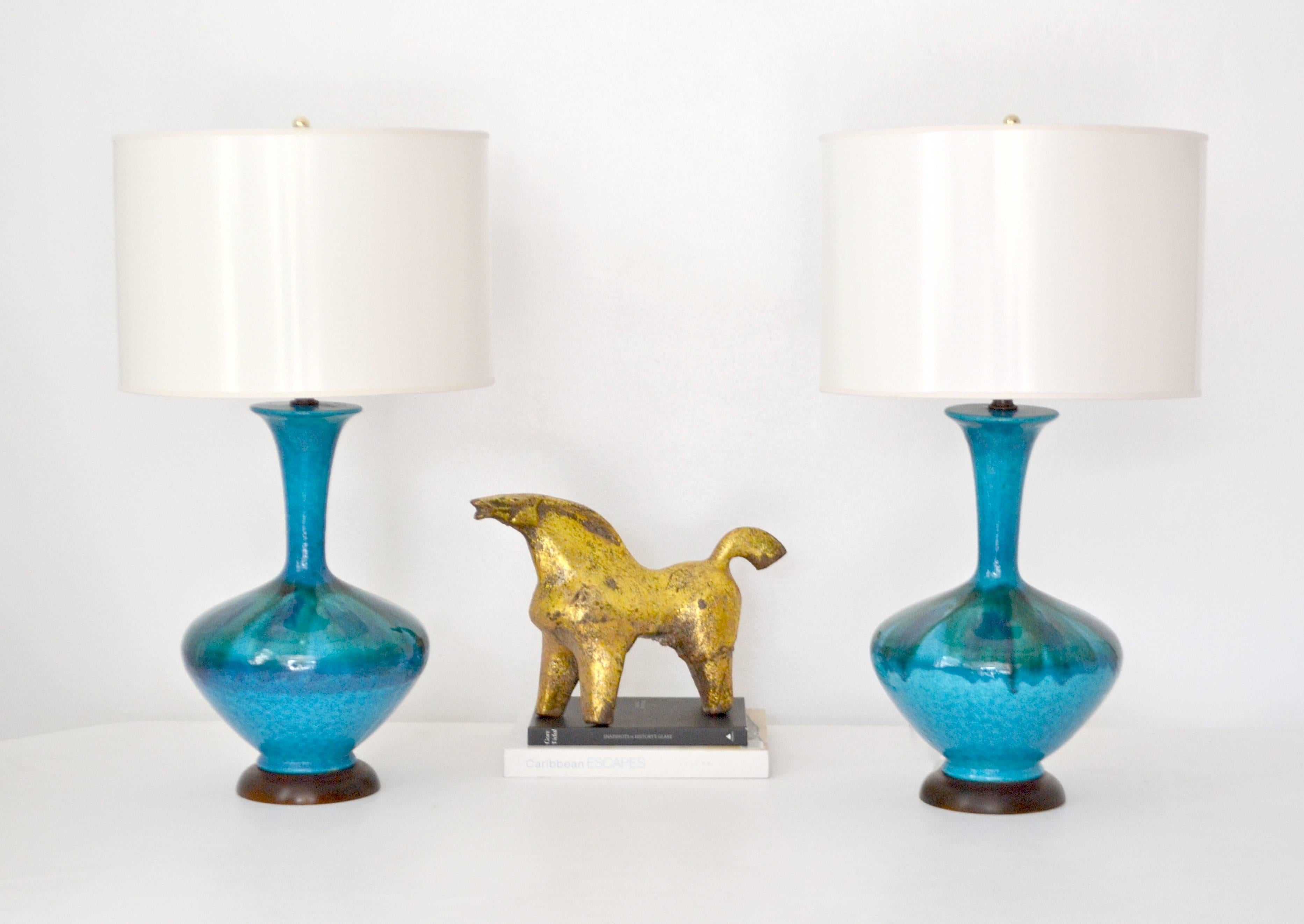 Striking pair of Mid-Century blue green polychrome crackle glazed ceramic jar form table lamps, circa 1950s-1960s. These stunning artisan crafted hand thrown lamps are mounted on turned wood bases and wired with brass fittings.
Shades not included.
