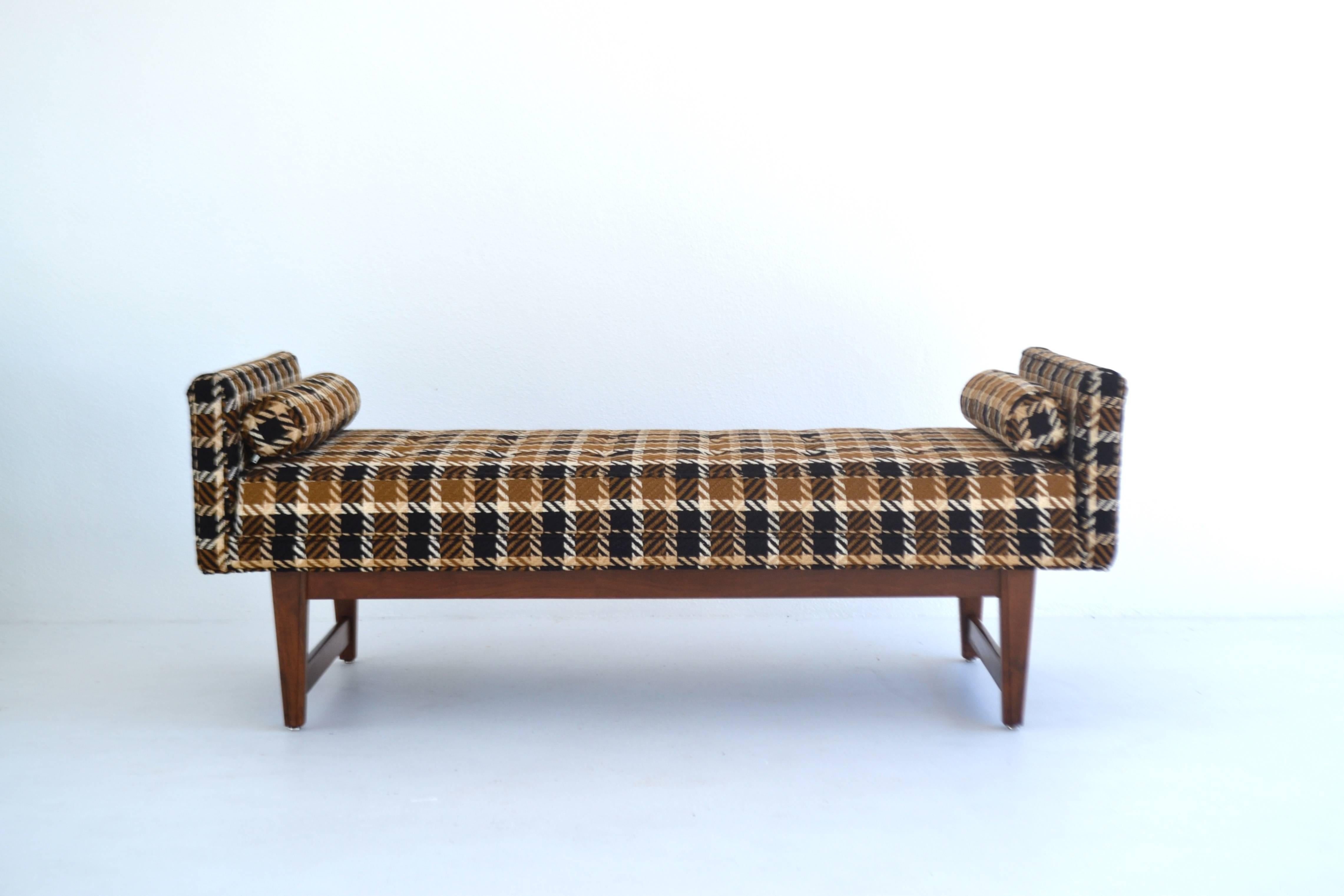 Striking Mid-Century upholstered bench by Selig, circa 1969. This striking sofa bench or bed bench is upholstered in the original wool fabric in excellent condition mounted on a walnut frame with two cylindrical accent pillows.