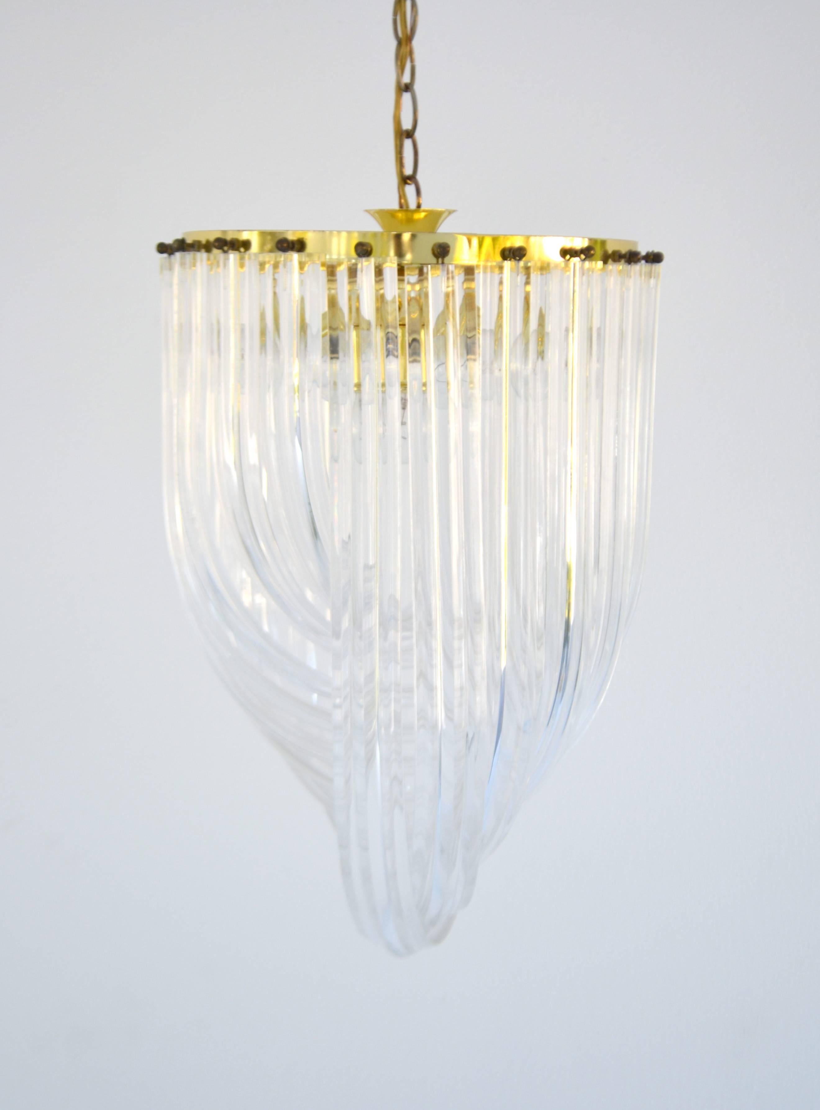 Glamorous Mid-Century acrylic crystal rod chandelier, circa 1960s - 1970s. This sculptural round chandelier is designed of intertwining loops of clear twisted lucite rods suspended from a brass frame.   
Measurements:
Overall: 14