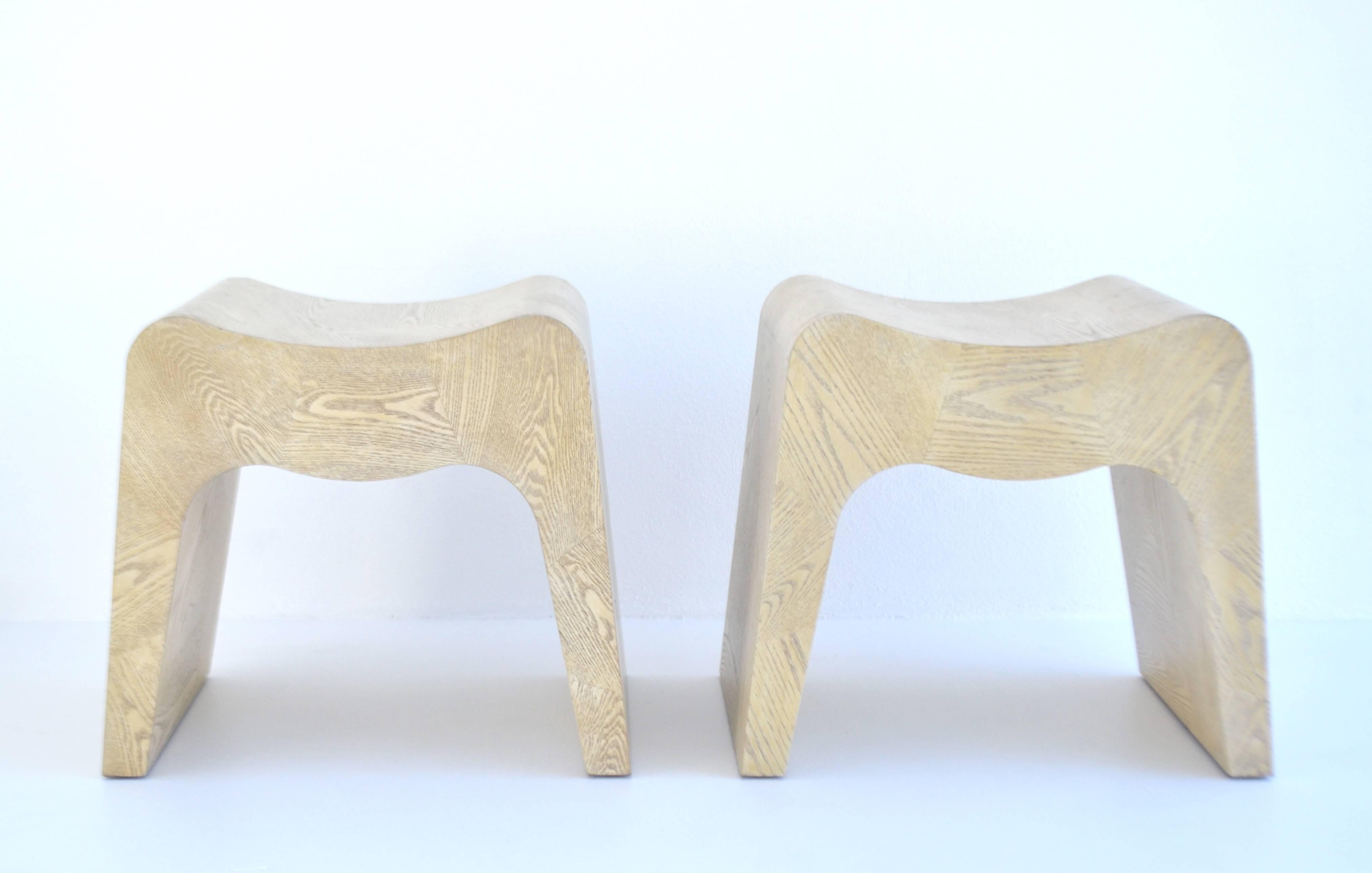 Striking pair of sculptural Postmodern stools, France, 1980s. These custom artisan crafted benches are designed of cerused oak veneer geometrical parquet patterns over molded solid wood forms.