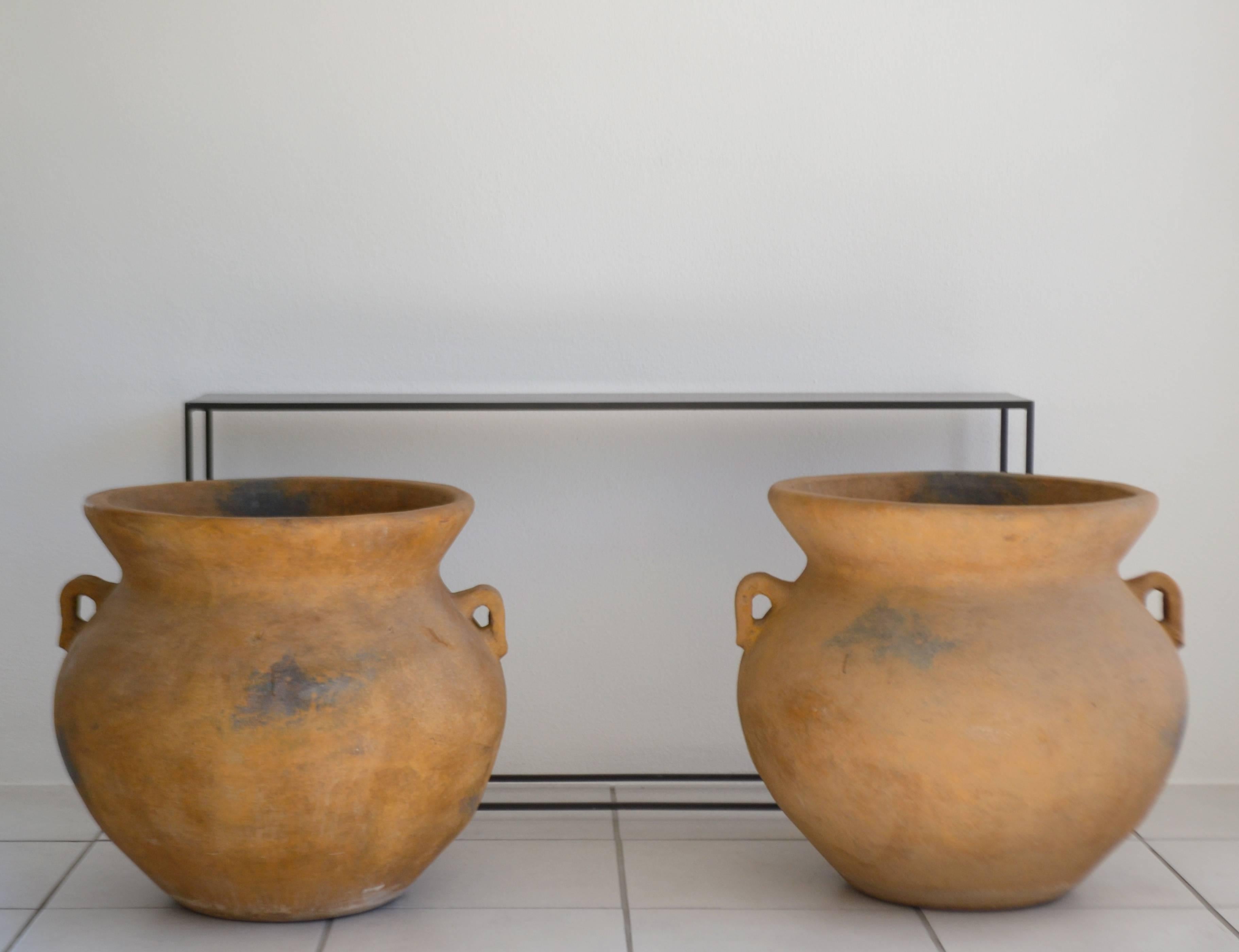 Pair of monumental Italian terracotta urn form garden planters, circa 1950s-1960s. These striking jardinieres have beautifully aged with a natural worn and weathered patina.
