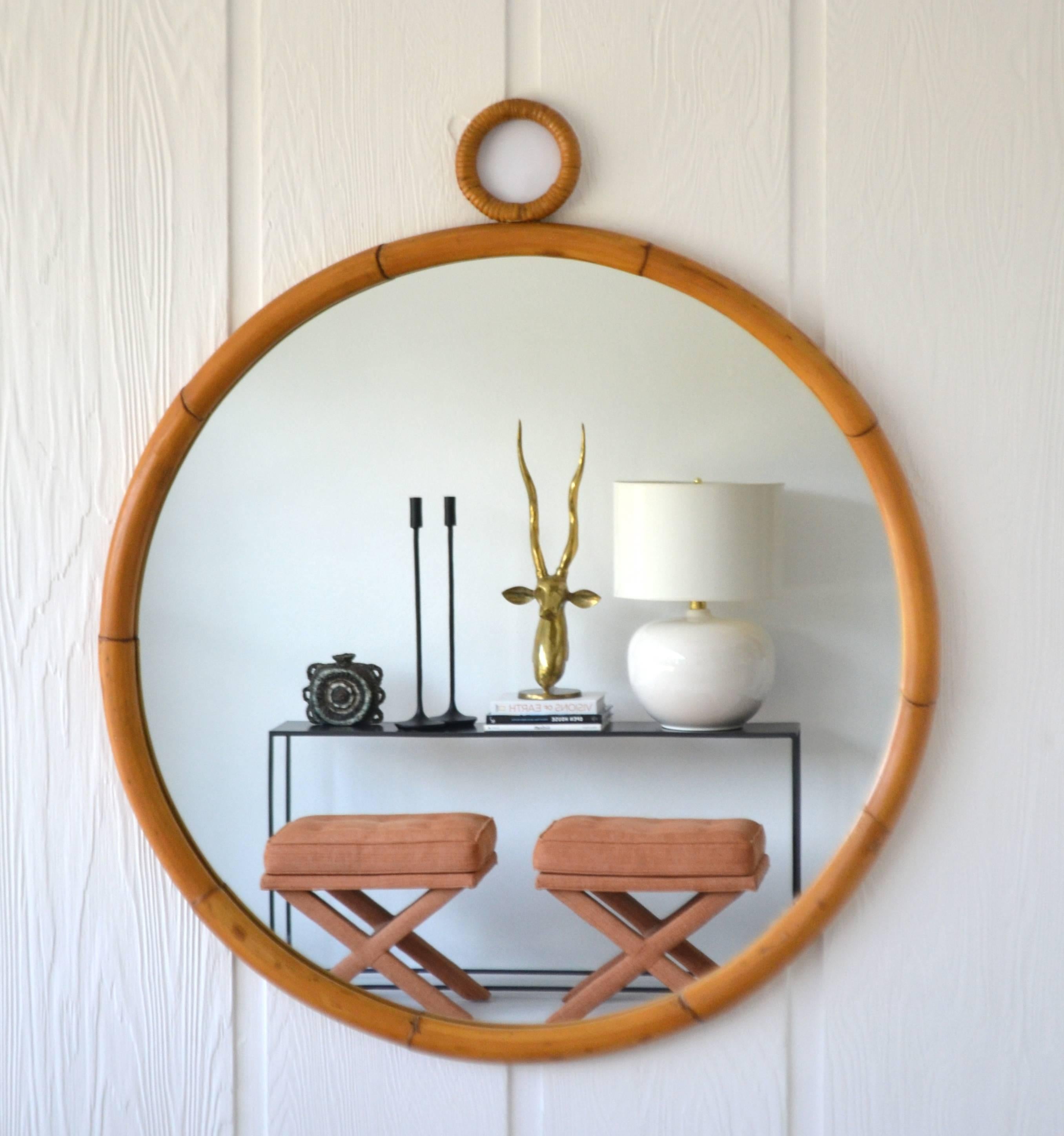 Glamorous Mid-Century bamboo wall mirror, circa 1960s-1970s. This stunning round Jacquqes Adnet / Gabriella Crespi inspired mirror is designed of bent bamboo and accented with wrapped rattan detail. Original excellent condition with a warm aged