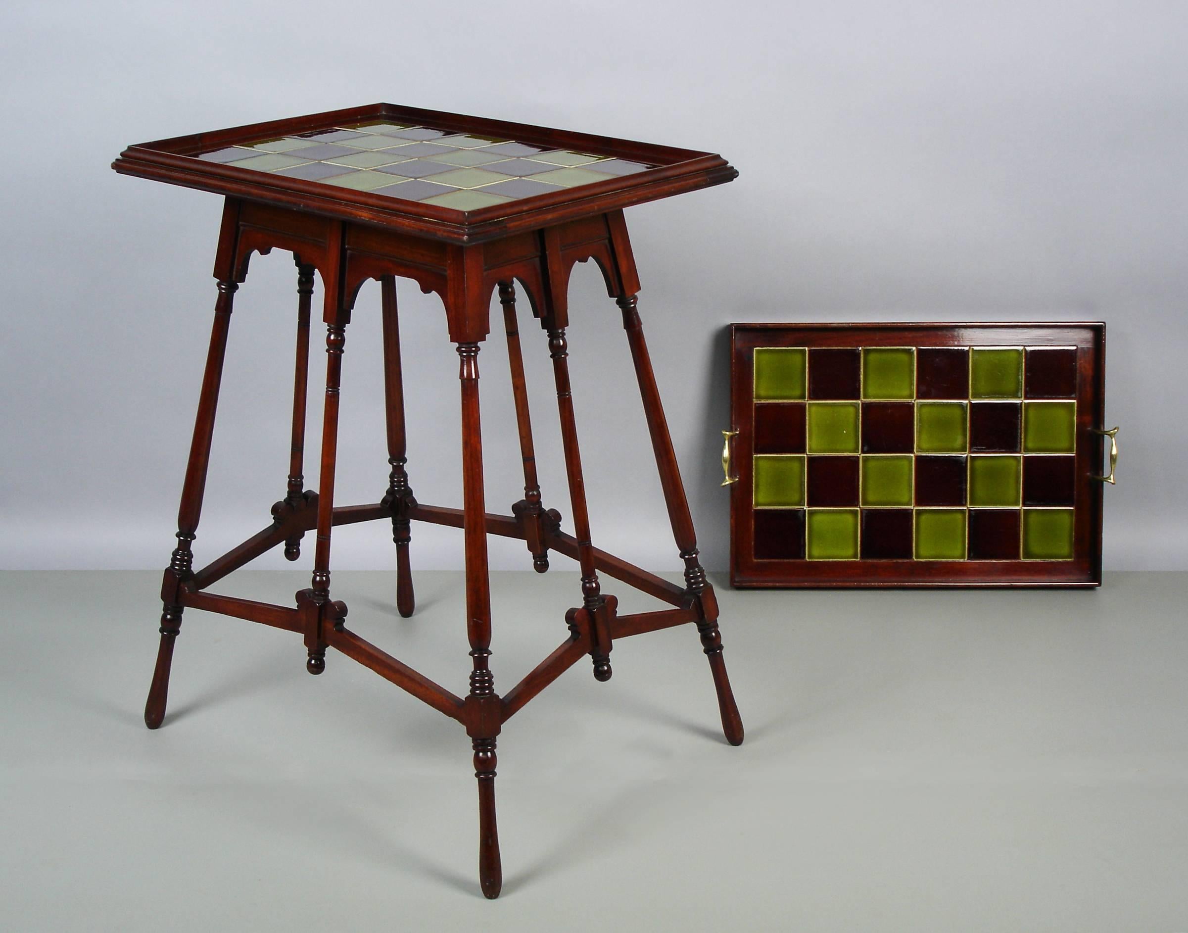 A late 19th century, Aesthetic Movement tea table with its tray. A brown and green tiles top supported upon four mahogany turned legs splayed with angular stretchers .A tray fitted to the table with a tiles top, a mahogany frame and bronze handles.