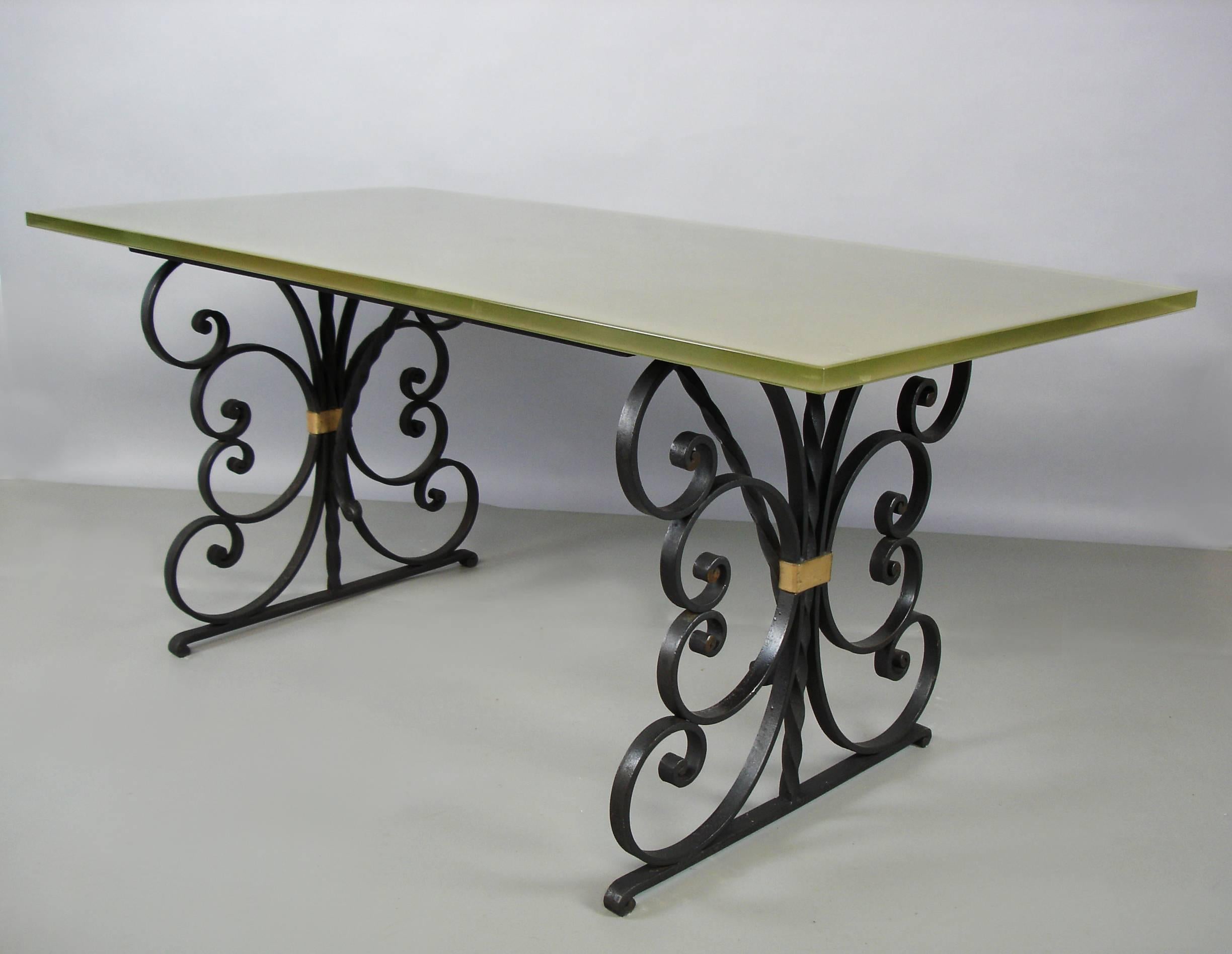A black painted and gilt wrought iron structure supporting a glass top. The glass is sand blasted and silvered, underneath, this give a green-gray aquatic color to the top.