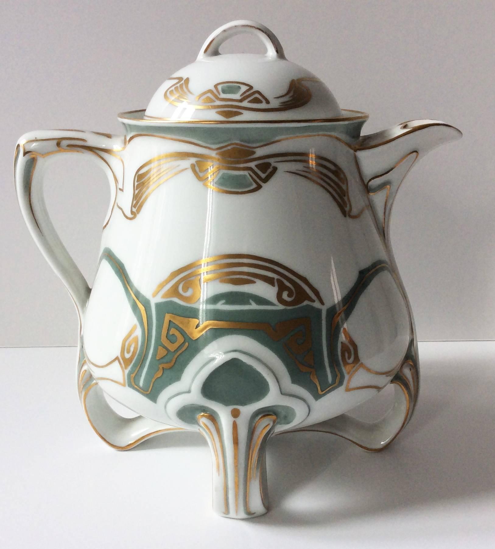 Seven glazed white, green and golden painted porcelain pieces set:
One tea or coffee pot with lid (dimensions: H 7in, depth 7.8in, width 5.8in).
One creamer (H 5.5in, depth 5.2in, width 4in).
One sugar pot with lid (H 4.7in, Diam 5.5in).
Two tea