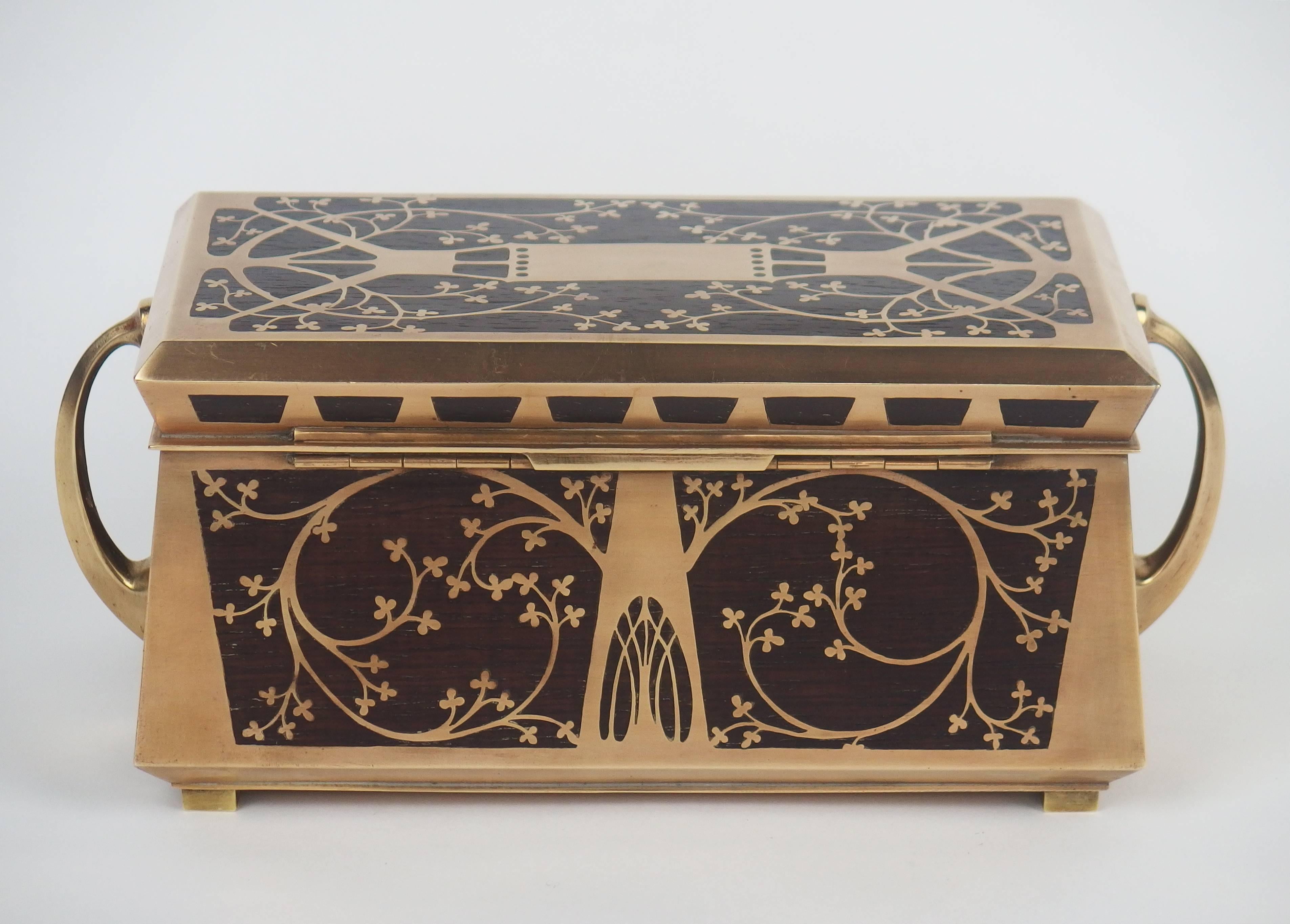 A jewelry box inlaid with rosewood and brass. Lyre birds decorations on the front. Original red velvet inside the box.