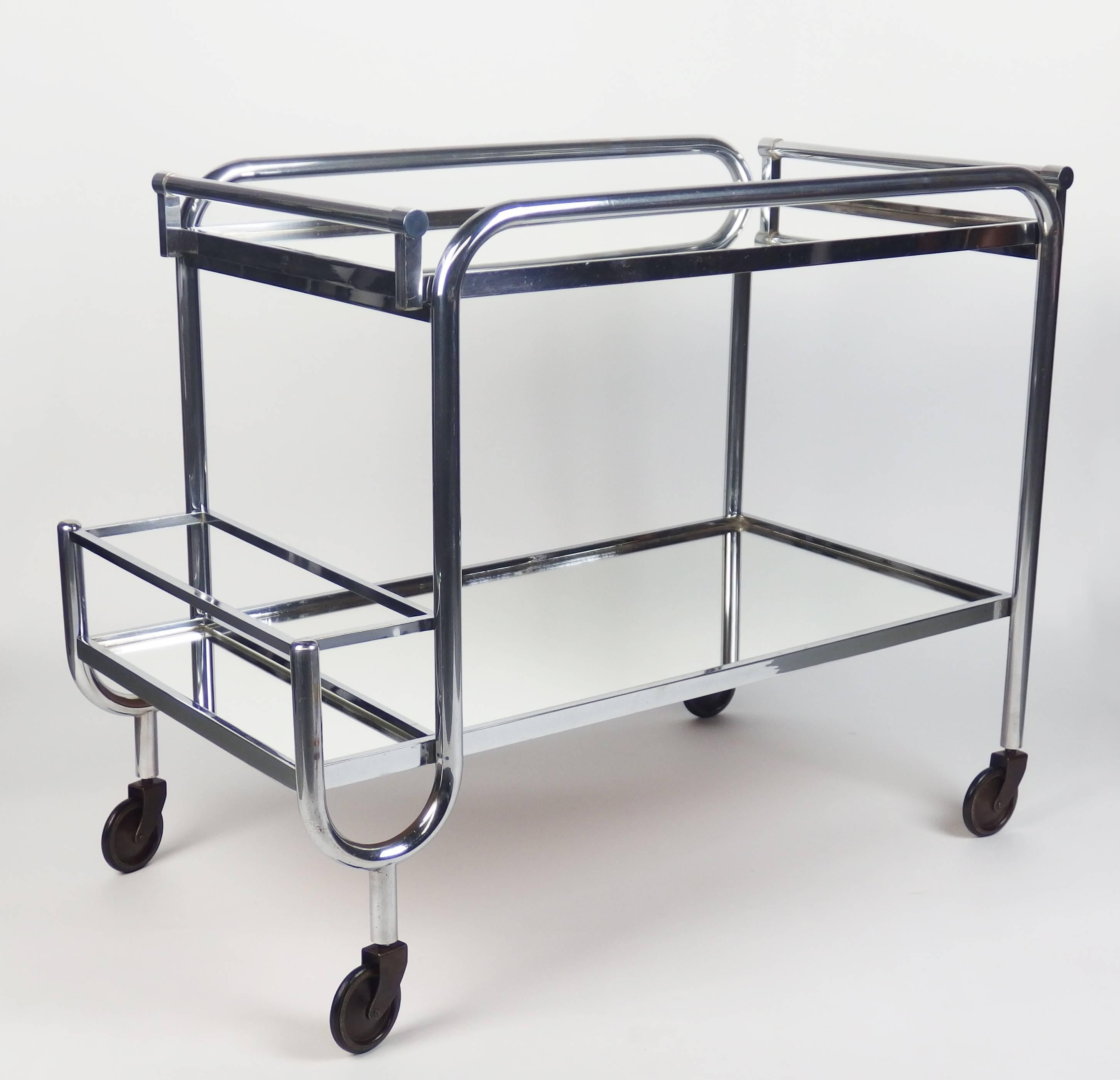 A serving bar cart in chrome and mirror with a removable serving tray.