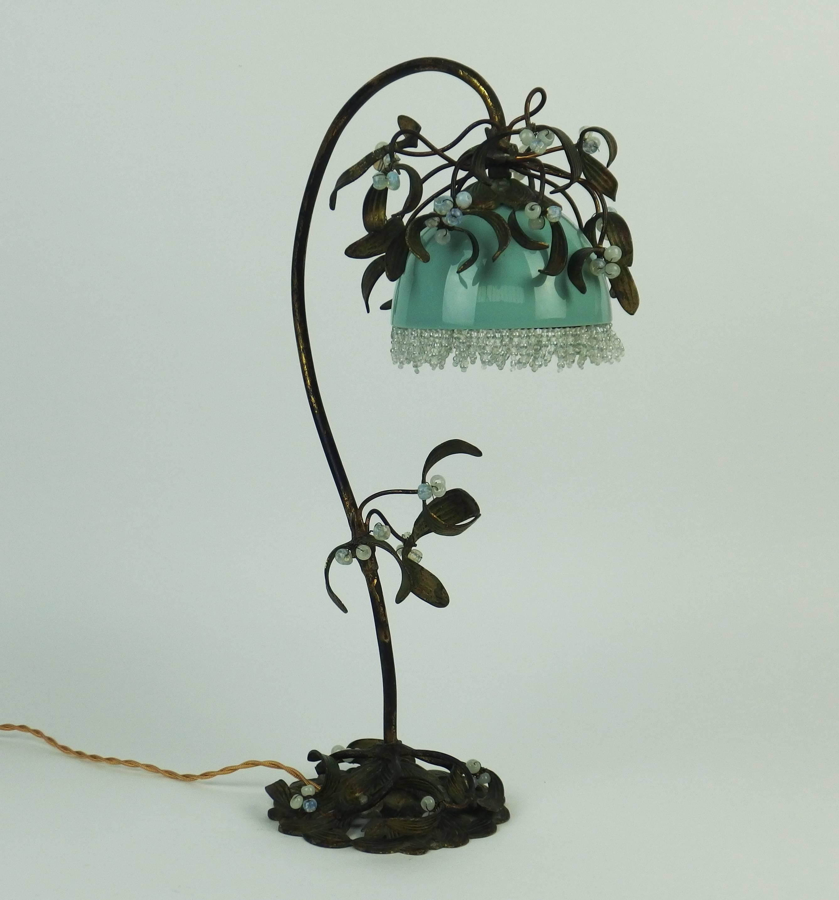 A rare brass and bronze mistletoe table lamp with green painted brass and bronze, small white pearls and a green glass shade.