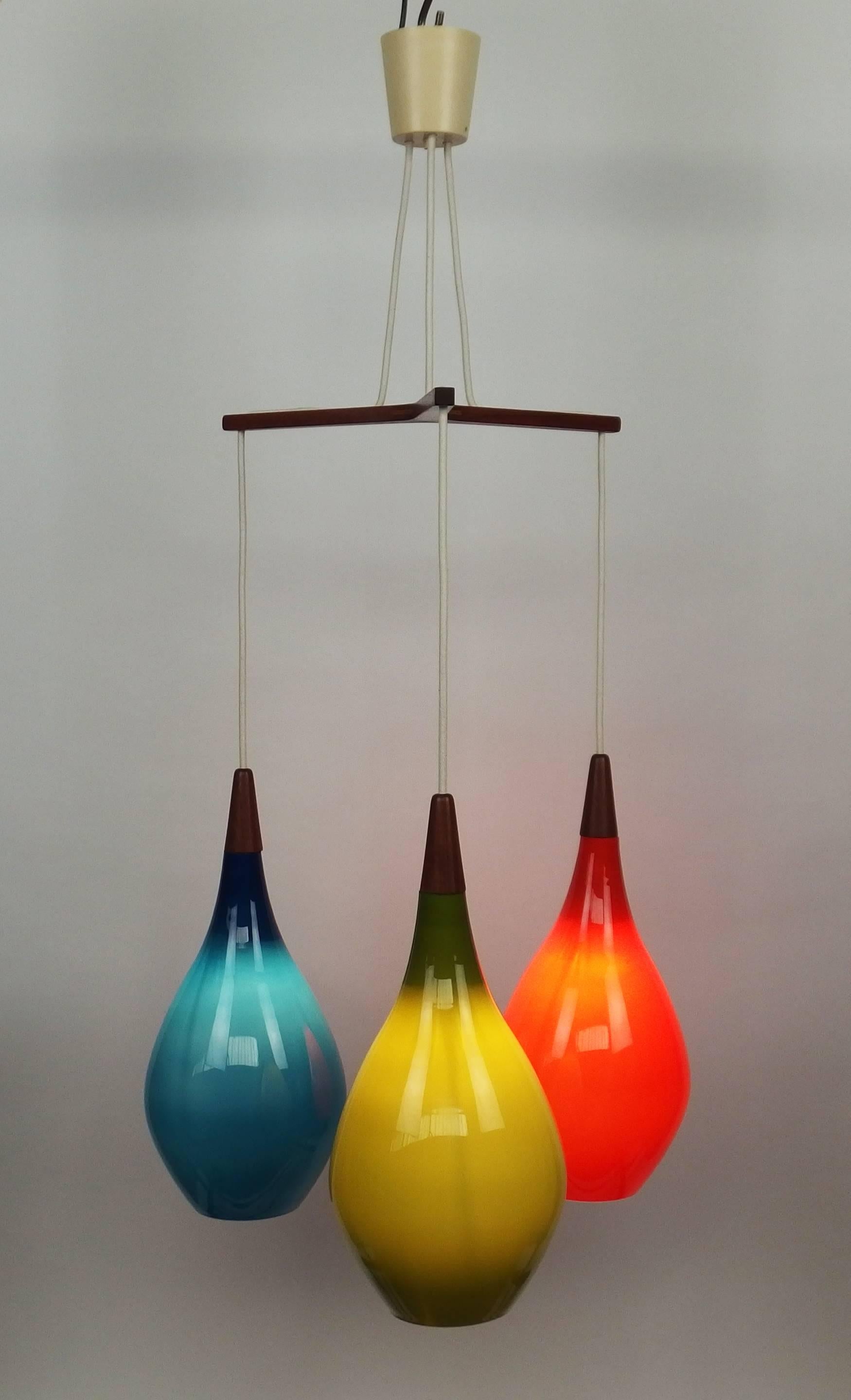 A Danish colorful Holmegaard chandelier with" tear drop" glass globes hung on a teak stand. The height of each globe is adjustable.
This chandelier is rewired with the original screw sockets.
globes dimensions: diameter 8 in, height