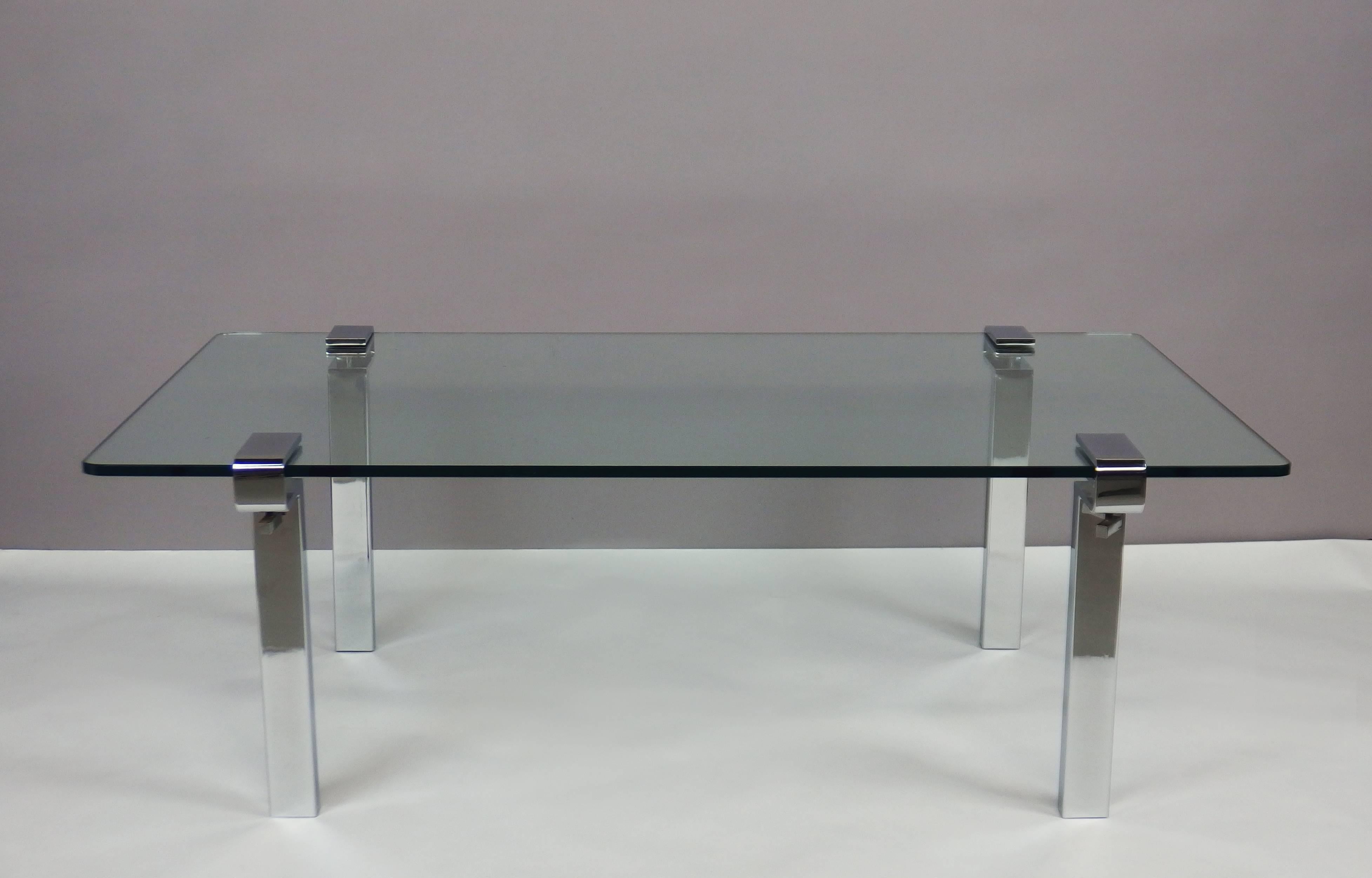 A coffee table with four cramp chromed steel legs holding a glass top.
This table was designed by François Arnal in 1971 and edited by Atelier A (1969-1975).
The cramp system gives the possibility to choose the size, the shape and the material of