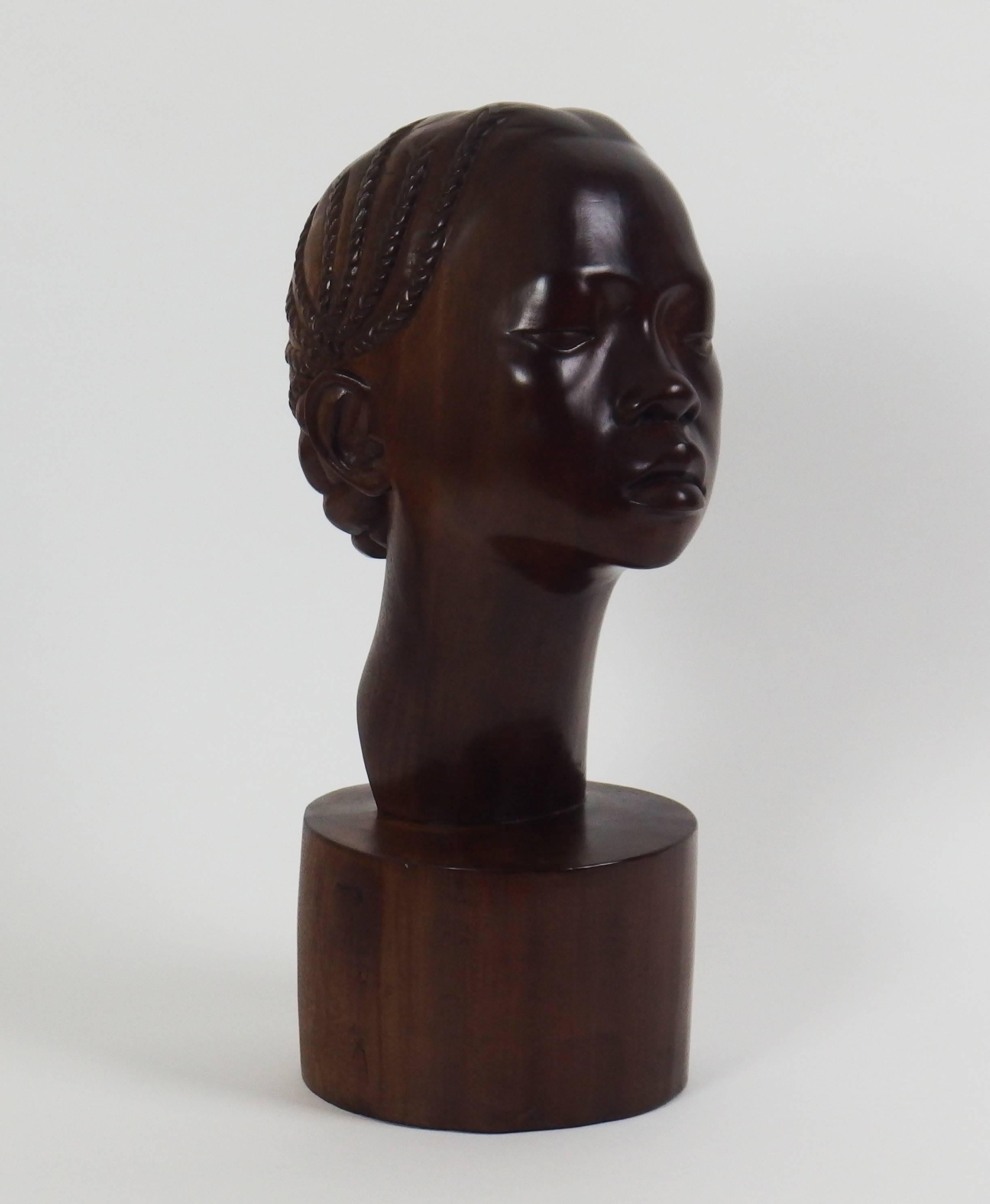 This young woman head in solid mahogany was sculpted by a Madagascan artist in 1940. Signed E.Rakotondrabé and dated 1940, under the sculpture.