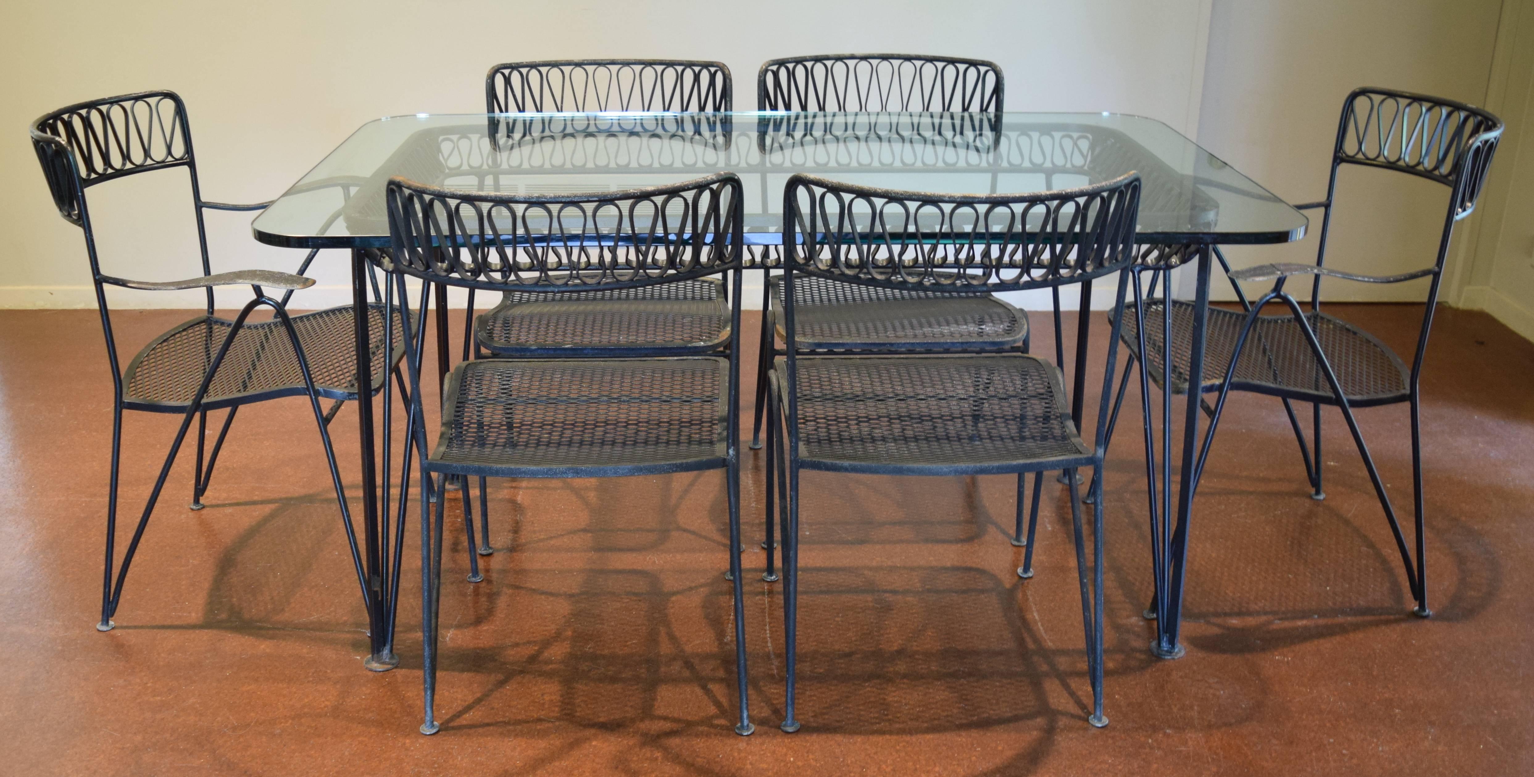 Beautiful seven-piece dining set from the famous ribbon line designed by Tempestini for Salterini. Includes a glass-topped table plus two armchairs and four side chairs. Please note: One side chair needs a simple weld fix (see last photo); we can