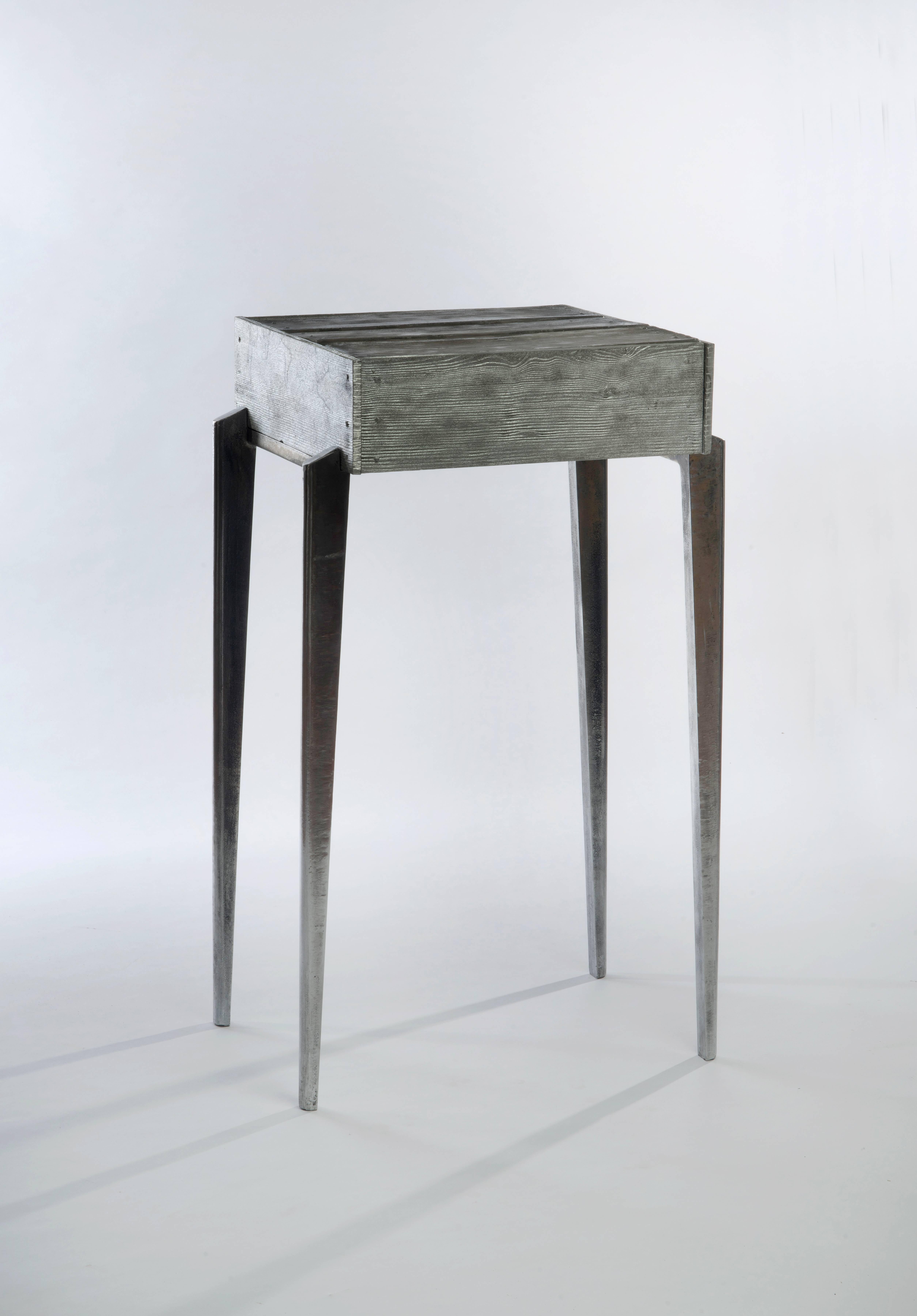Gregory Nangle
Aluminum Shack Side Table, 2017
Cast aluminum, mirrored glass
22 x 18 x 38 in

The Gregory Nangle aesthetic explores what happens when geometry is interjected into nature. His work juxtaposes Minimalist geometry with forms or essences