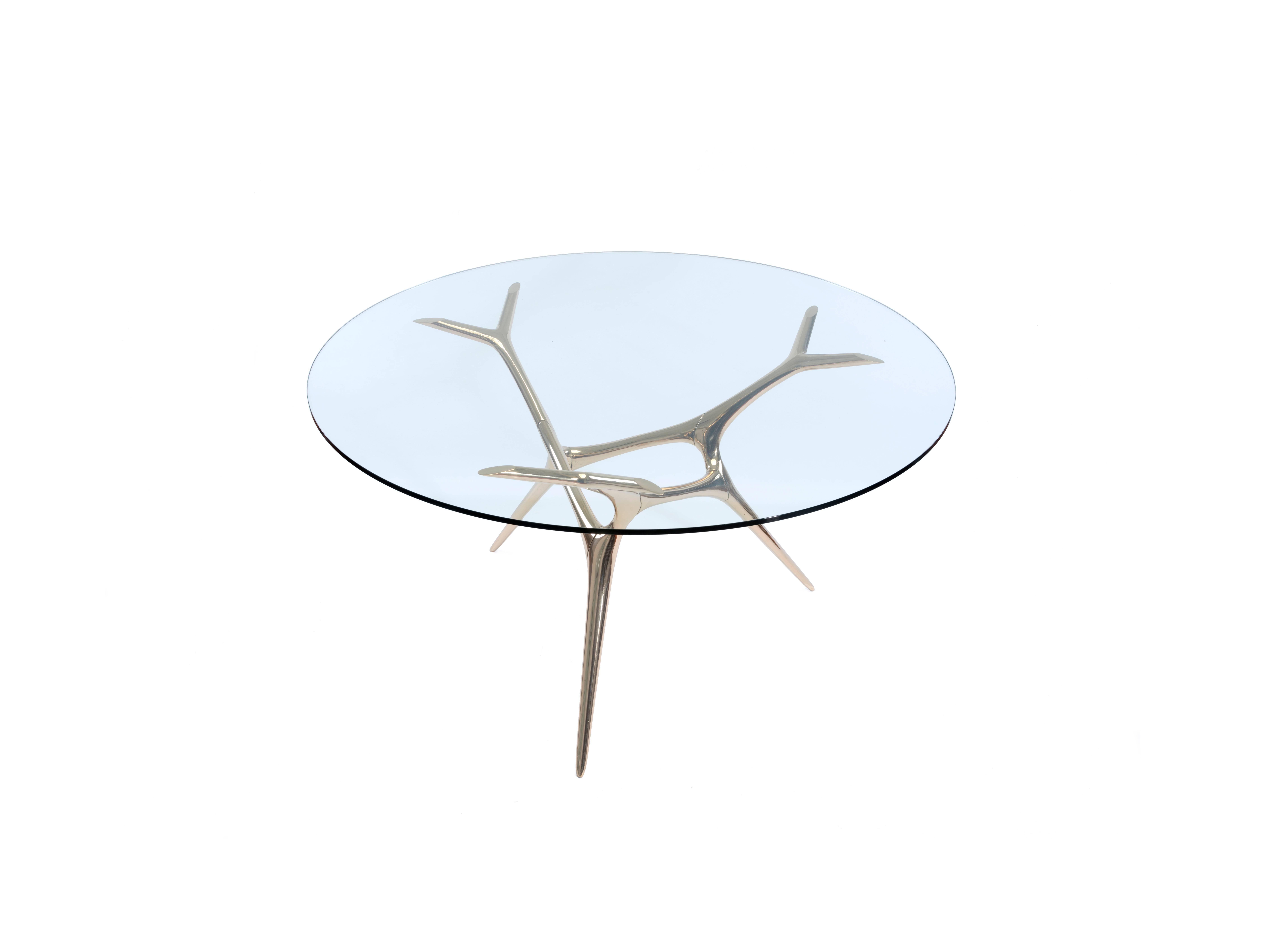 E-Volved Table was fabricated out of cast and polished bronze and glass by designer Timothy Schreiber.

Also available in polished stainless steel.

Timothy Schreiber initially trained in cabinet making in Germany before studying architecture and