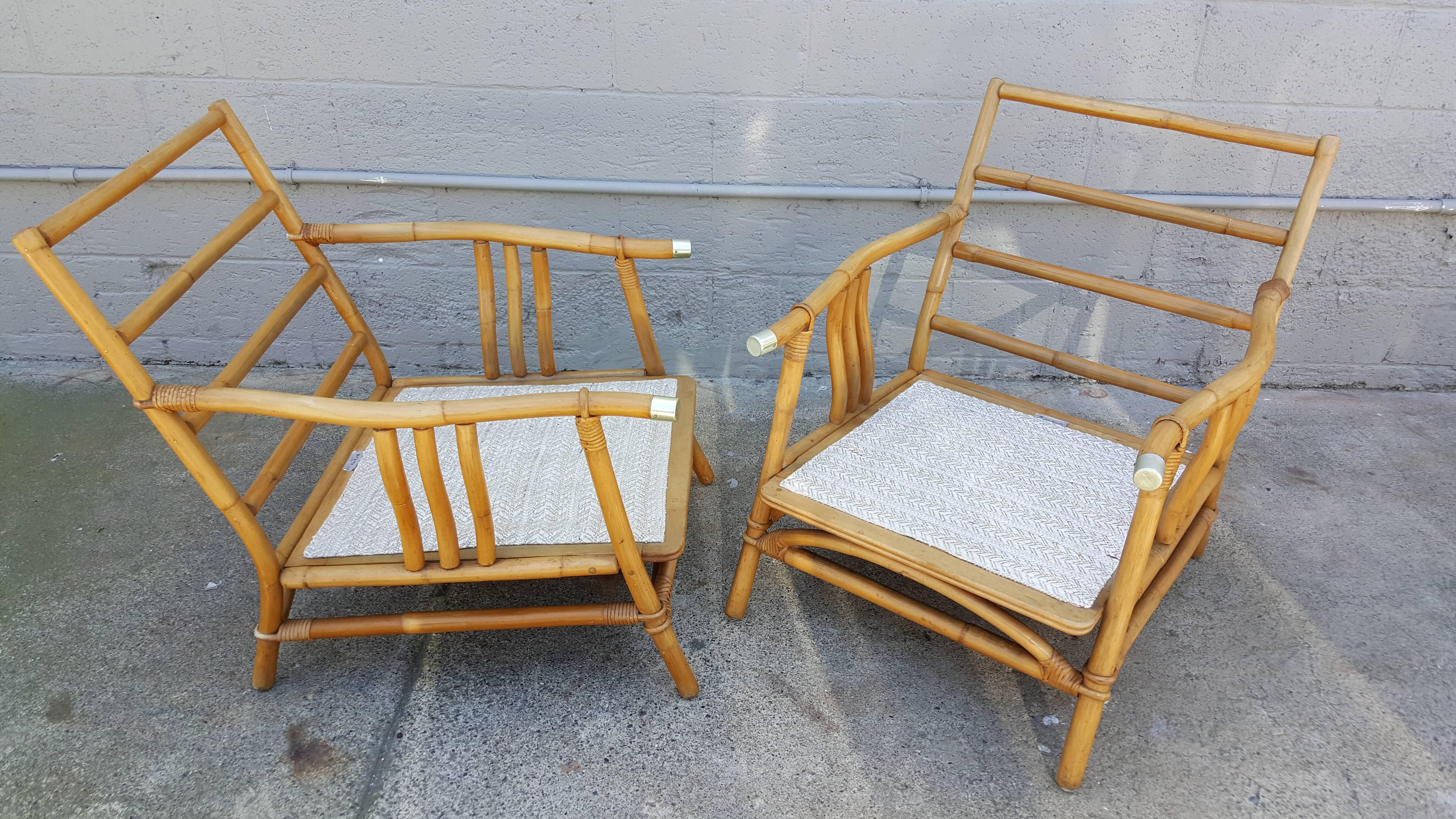 A pair of bamboo lounge chairs by Ficks Reed Company, circa 1960s. Quality craftsmanship. Elegant, graceful design to contoured arms and arched front stretcher. A very comfortable pairs of loungers with a nice glow to patina on the original finish.