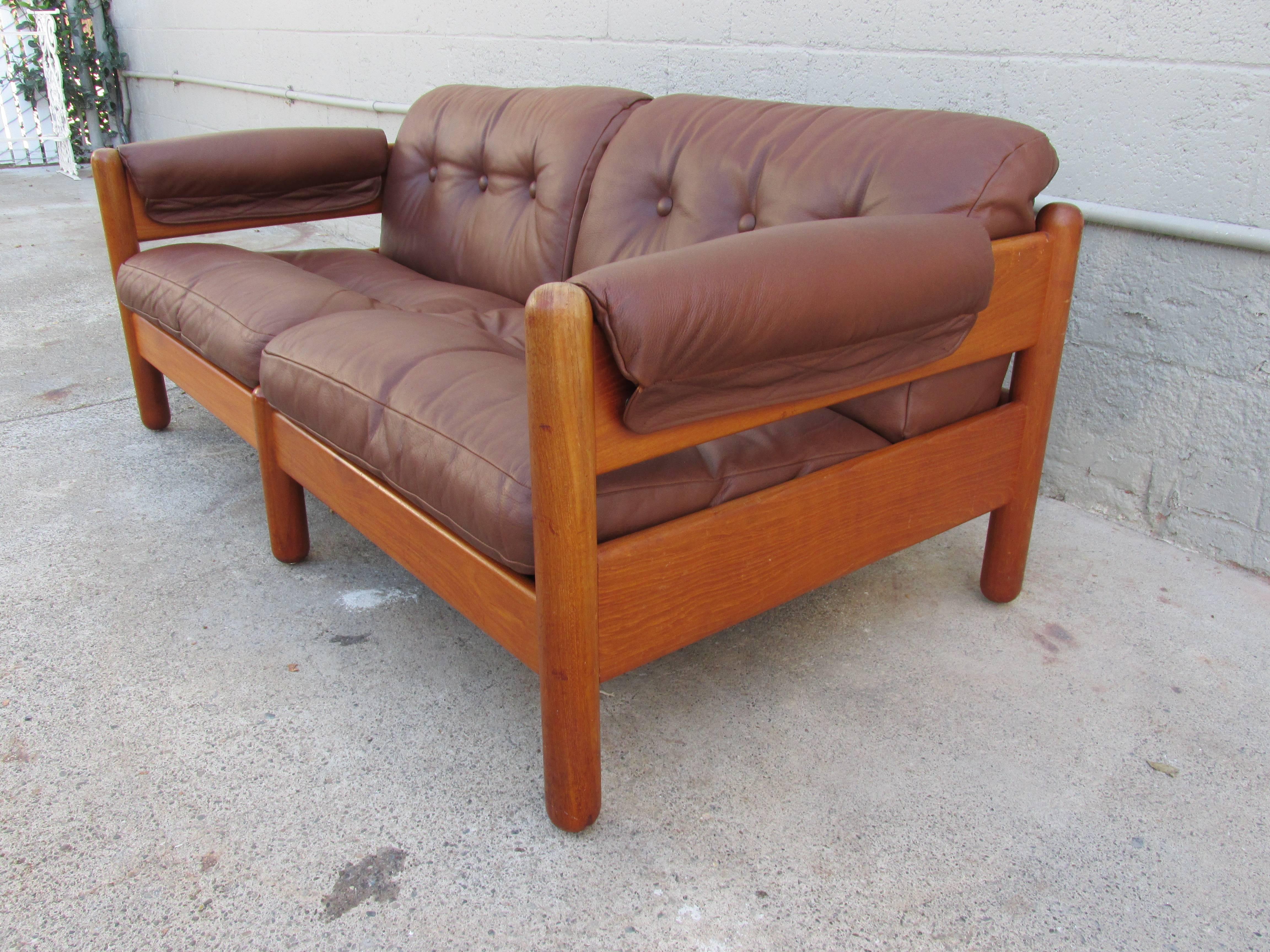 A solid teak and leather Danish modern sofa by A. Mikael Laursen, circa 1960s. Laursen produced pieces for top level designers such as Hans Wegner and Illum Wikkelsø. The designer of this sofa is unknown. Original leather and original finish in