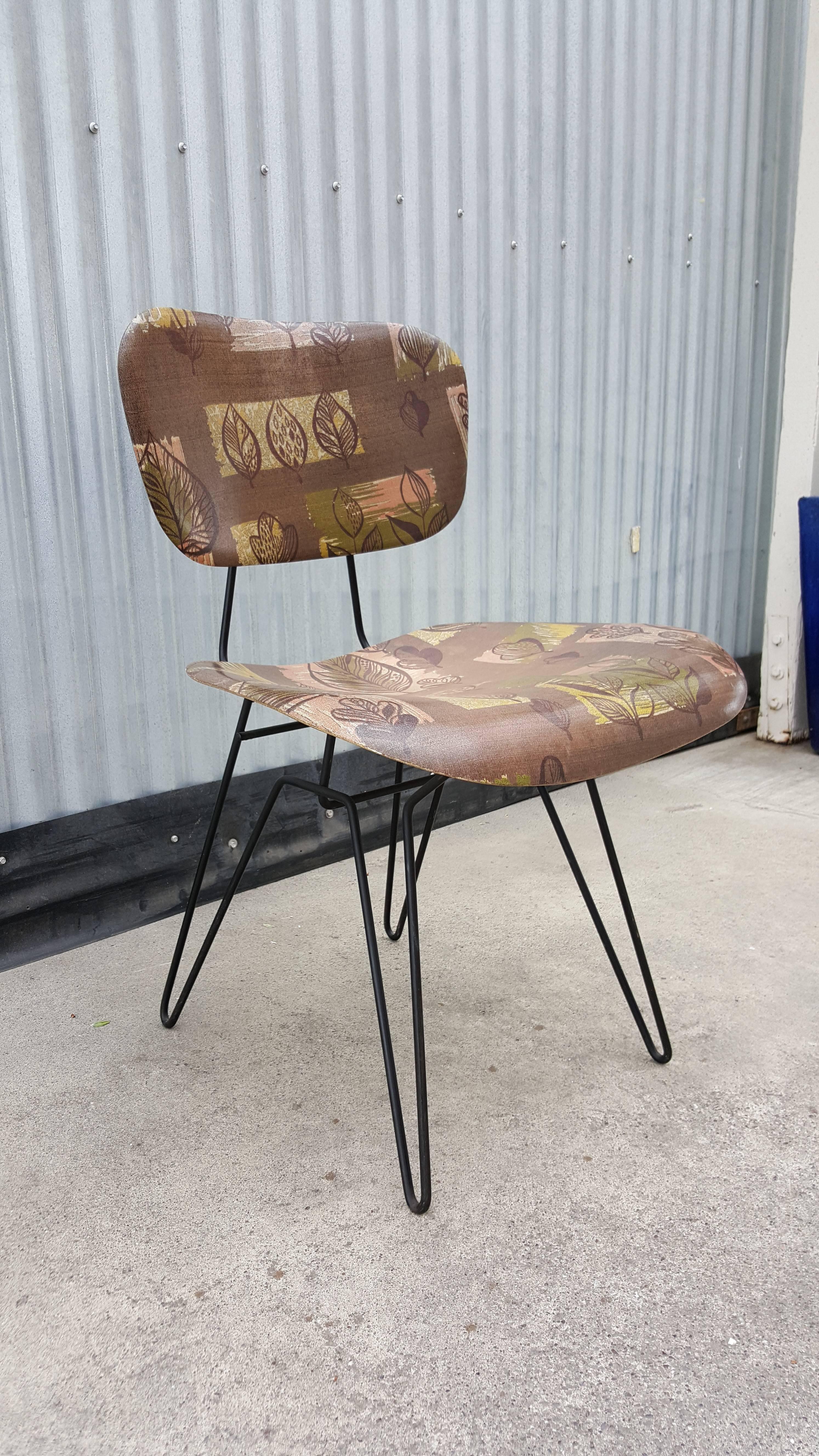 A twist on classic Mid-Century Modern design with a floral pattern formed fiberglass seat and back rest floating on an iron hairpin base. Shock mounts used are similar to the style used in the Charles & Ray Eames fiberglass chairs. Designed by