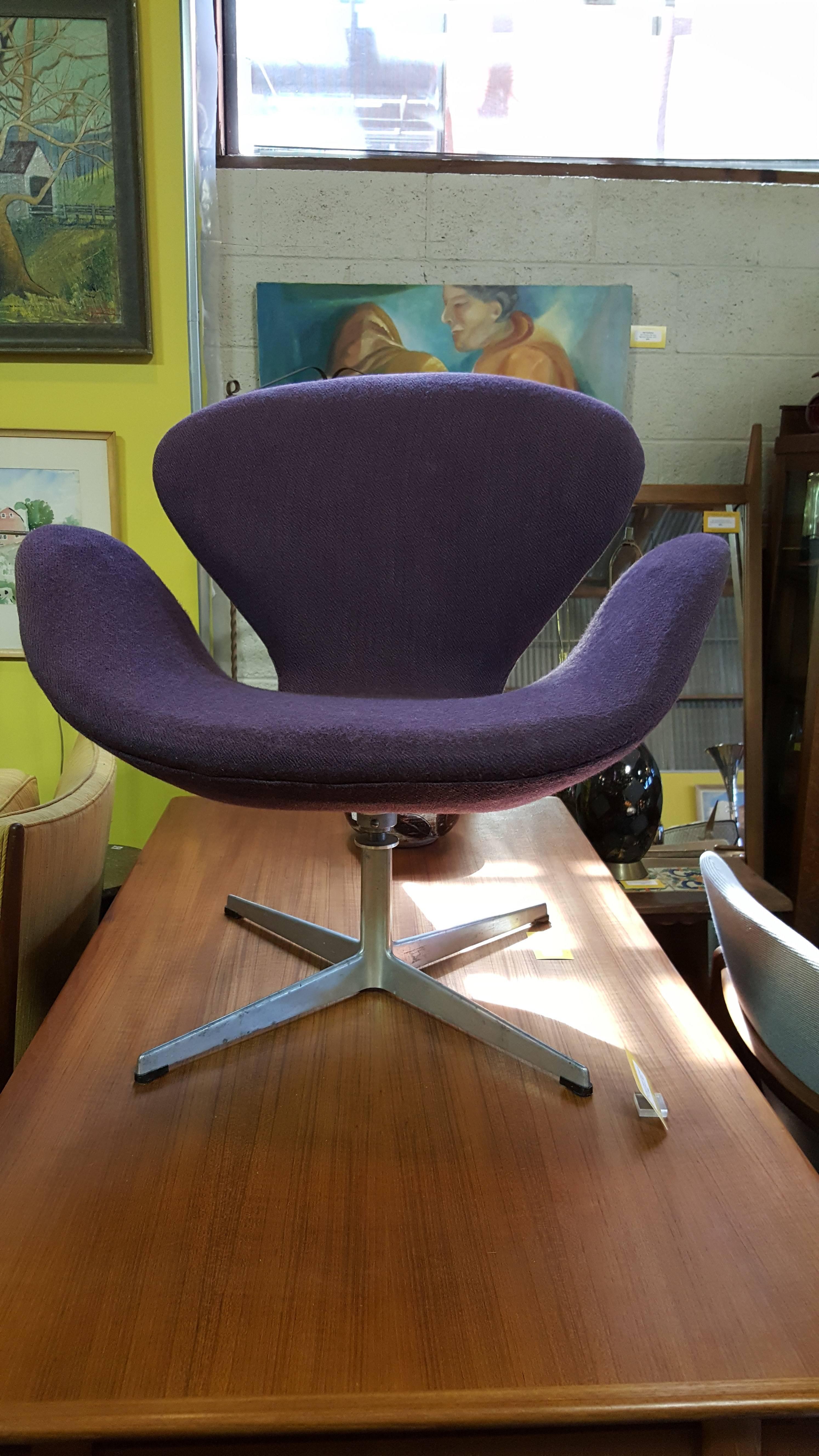 Iconic "Swan Chair" with original purple upholstery and retaining Fritz Hansen label. Cast aluminum segmented swivel base. Good, original vintage condition. Patina to segmented aluminum base ads character. 