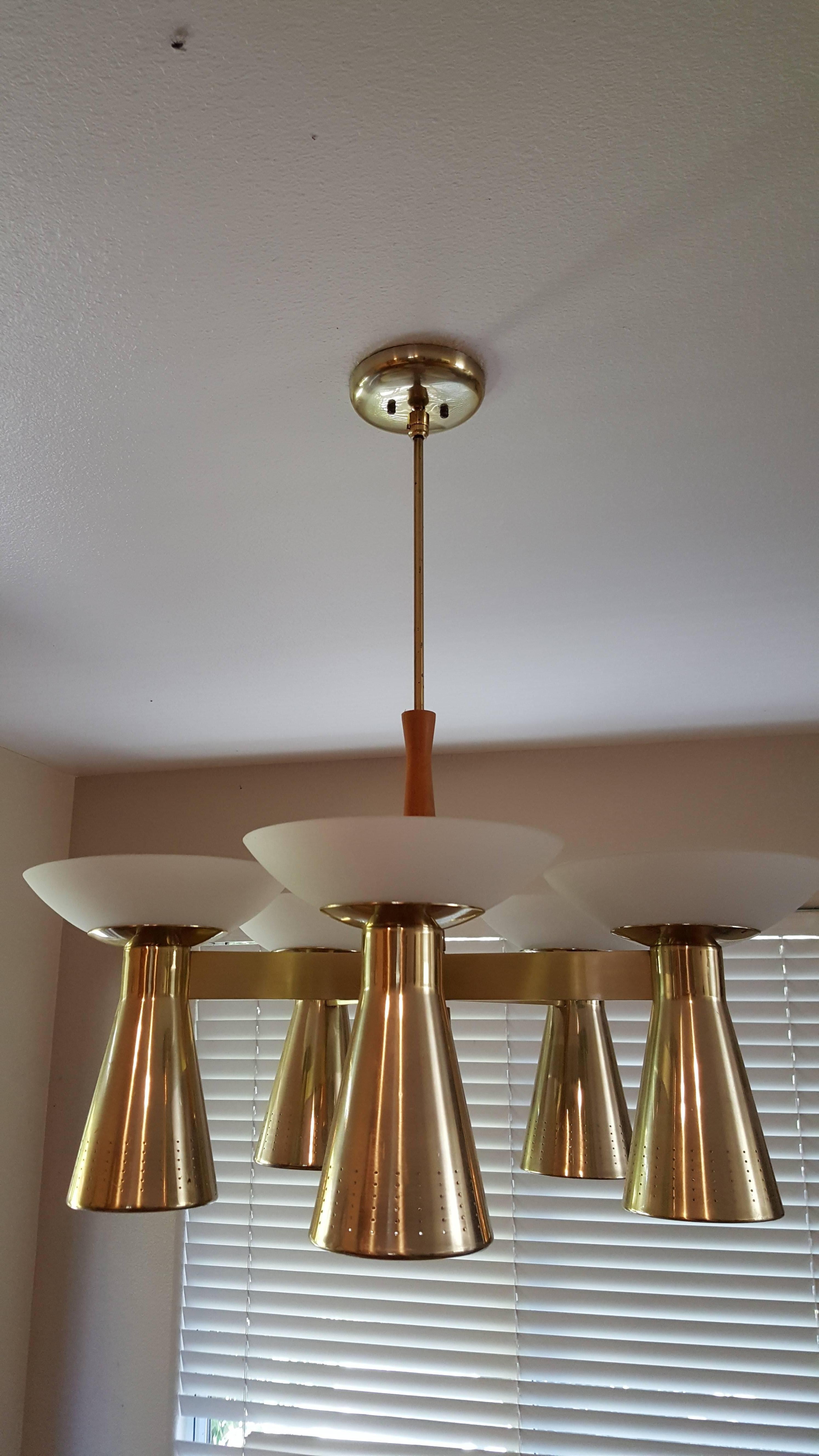 Classic Danish Modern design ceiling fixture. Conical brass down lights with classic pierce cut detail. Satin glass opaque up light shades. Beautiful polished brass finish with a walnut center support. Versatile lighting options with 5 up-light and