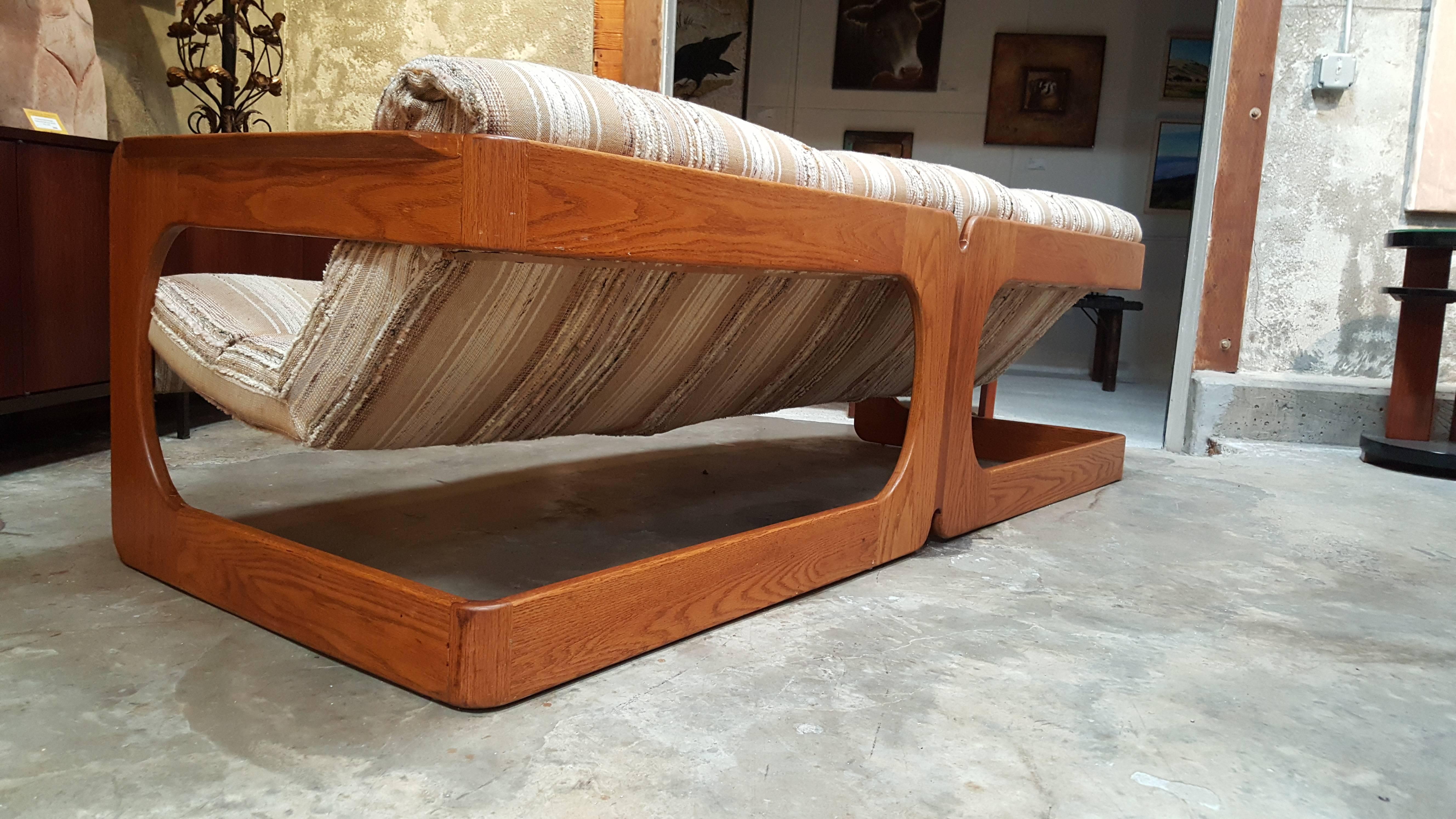 A Mid-Century Modern cantilevered or sling sofa designed by Lou Hodges, California, circa 1970s. Made of solid cross-cut oak with a finger-joint detail. Original finish and fabric.